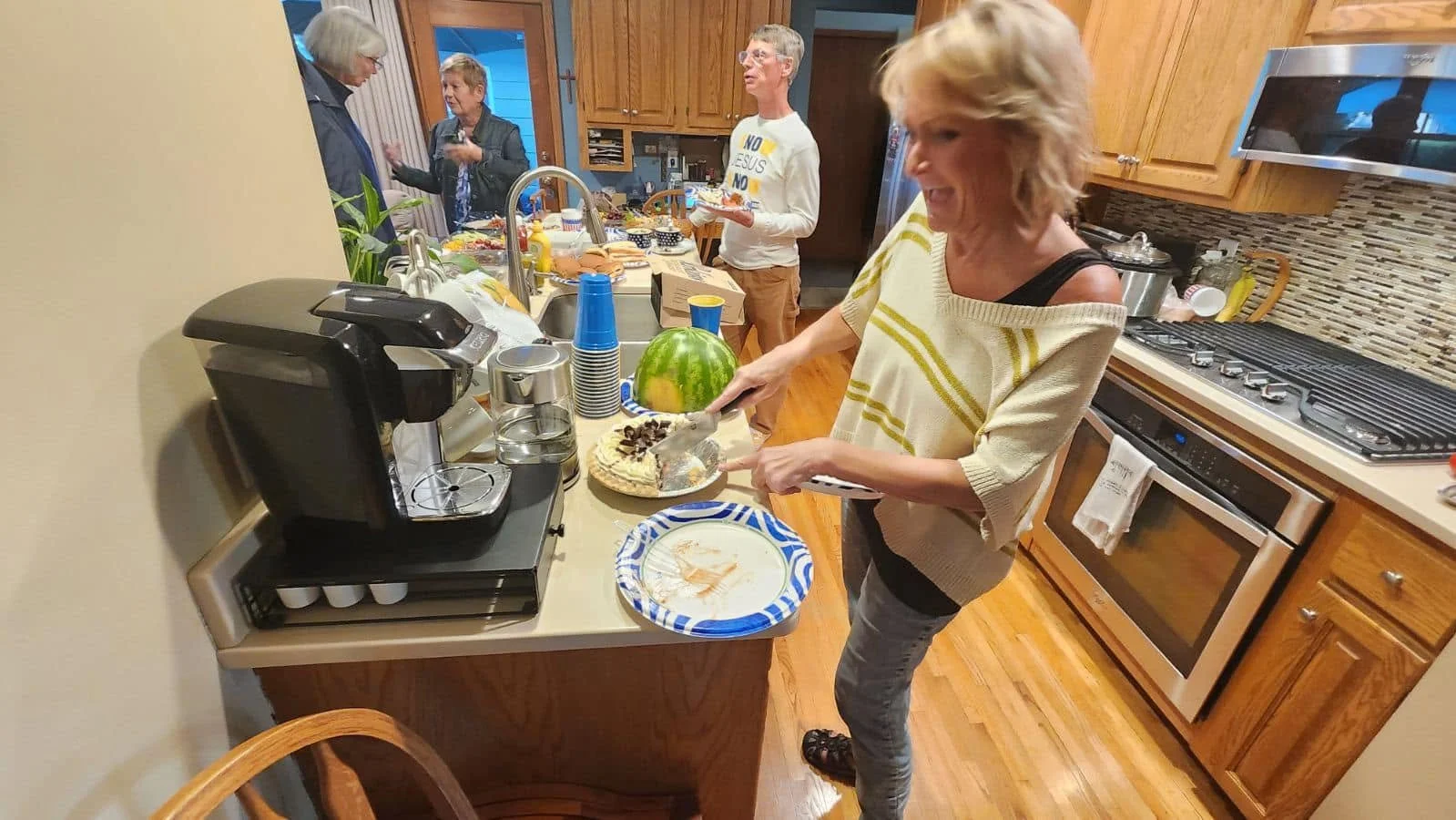 People in Kitchen with countertop full of potluck food