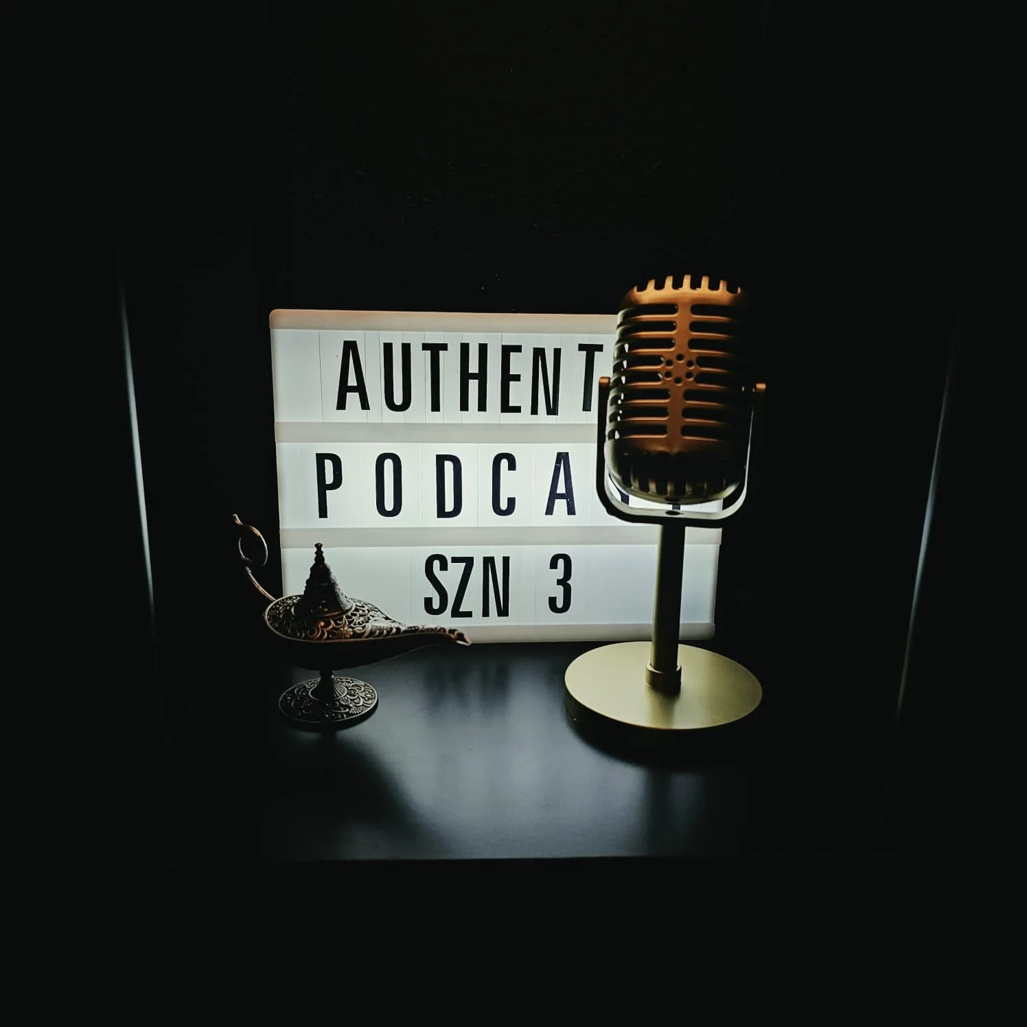 Lightbox sign displaying 'AUTHENTIC PODCAST SZN 3' with a vintage microphone and an ornate mini chair in front of it.