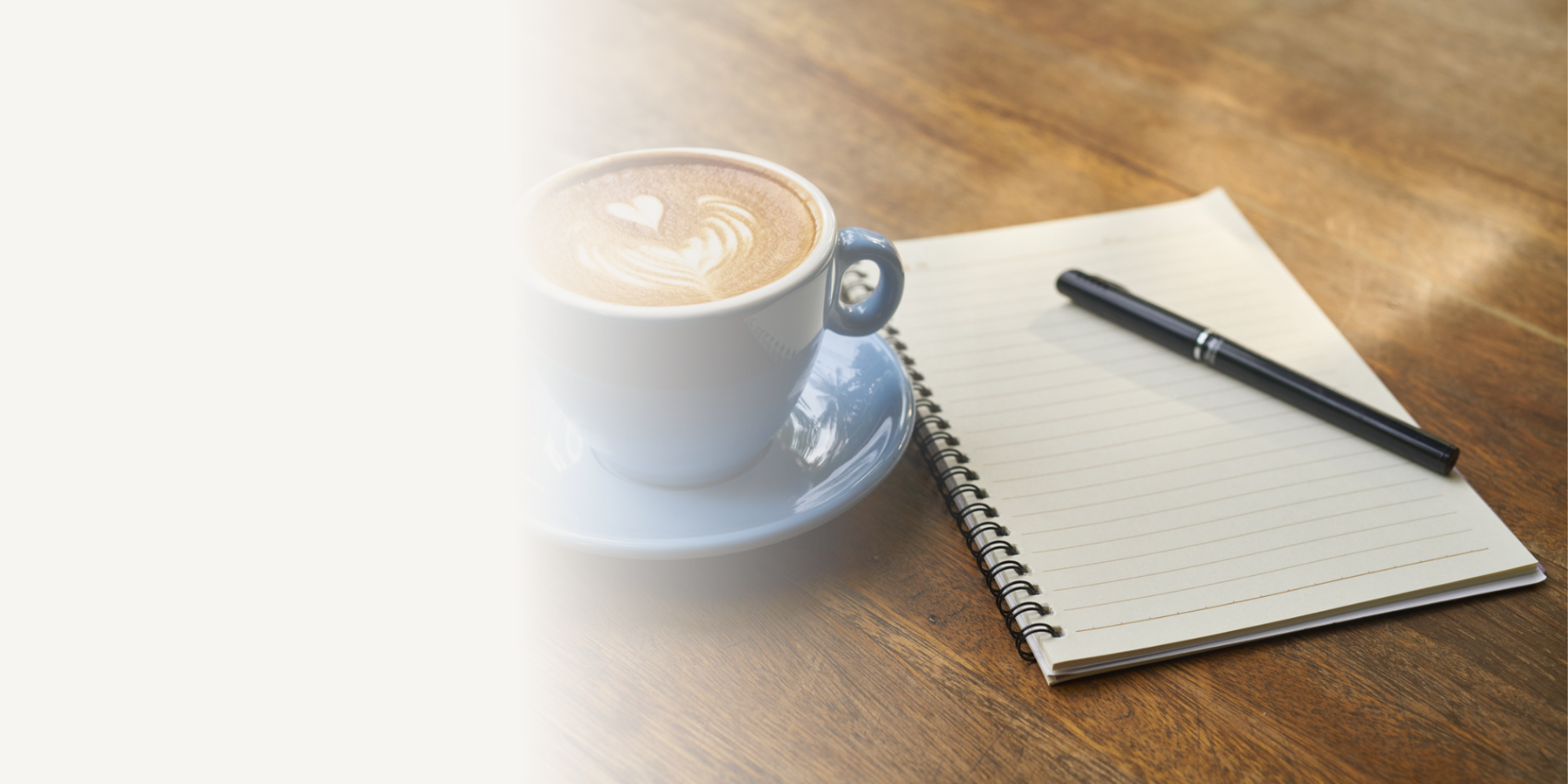 Coffee beside an open notebook, representing taking time to gain clarity, plan your next steps and navigate commissioning with confidence.