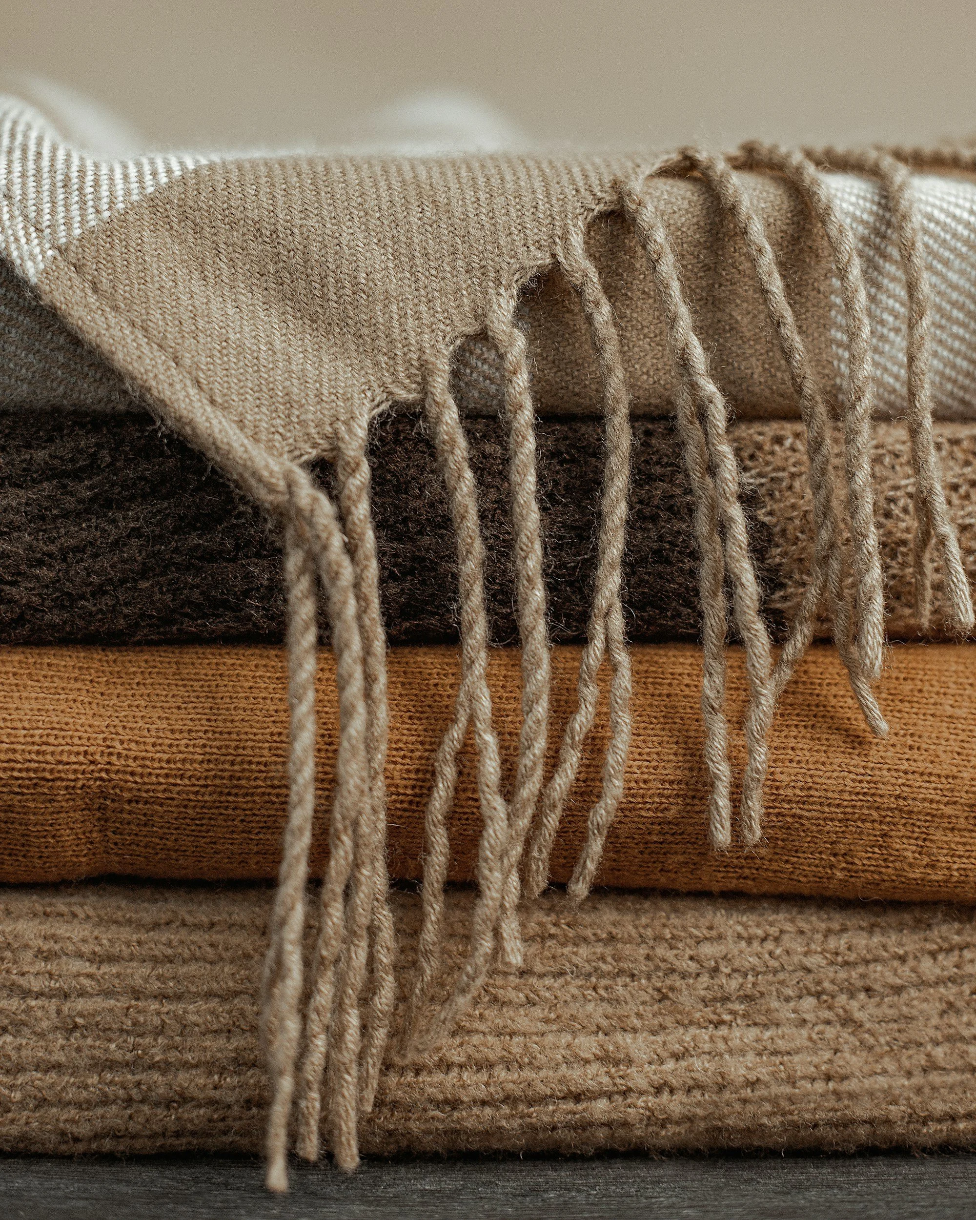 Closing of the bones photo: Sacred Closing of the Bones post partum healing Ceremony with 
rebozo-mixup of multiple textured fabric blankets layered, with a knitted beige blanket at the top and a brown wool blanket at the bottom, on a flat surface.