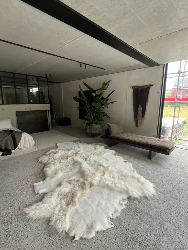 Mieke 201 by Wol Society, a large ivory sheep skin rug with long, wavy fleece flecked with blush and taupe