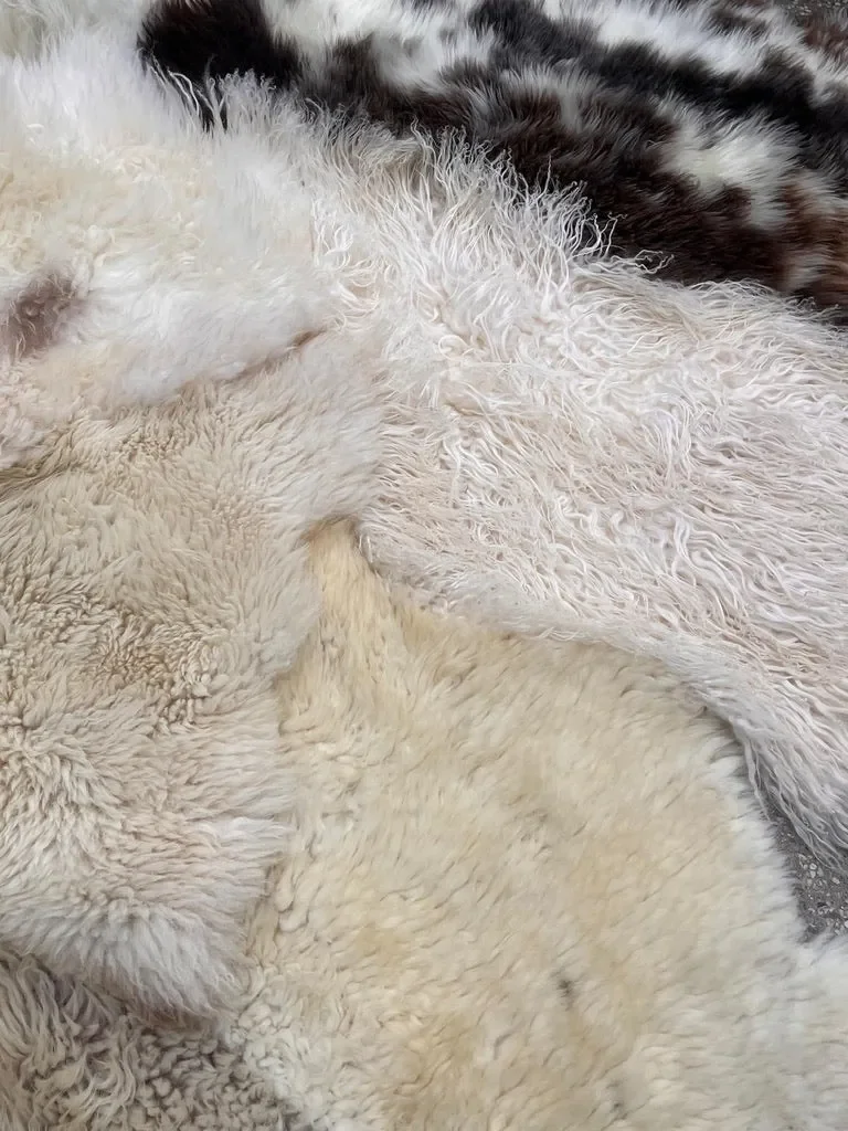 Pipper by Wol Society, a giant cream and ivory sheep skin rug with grey-brown curls and a speckled pelt