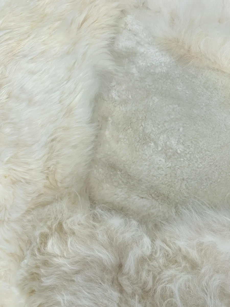 Mieke 189 by Wol Society, a large creamy white sheepskin rug with fluffy and smooth fleece