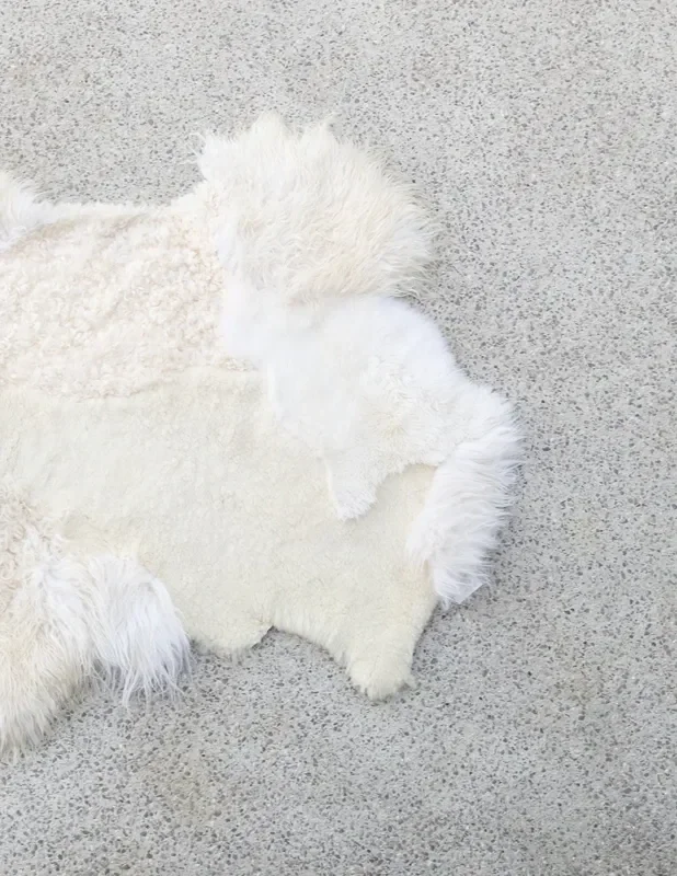 Bloom by Wol Society, an ivory sheep skin rug with a curly center and fluffy edges