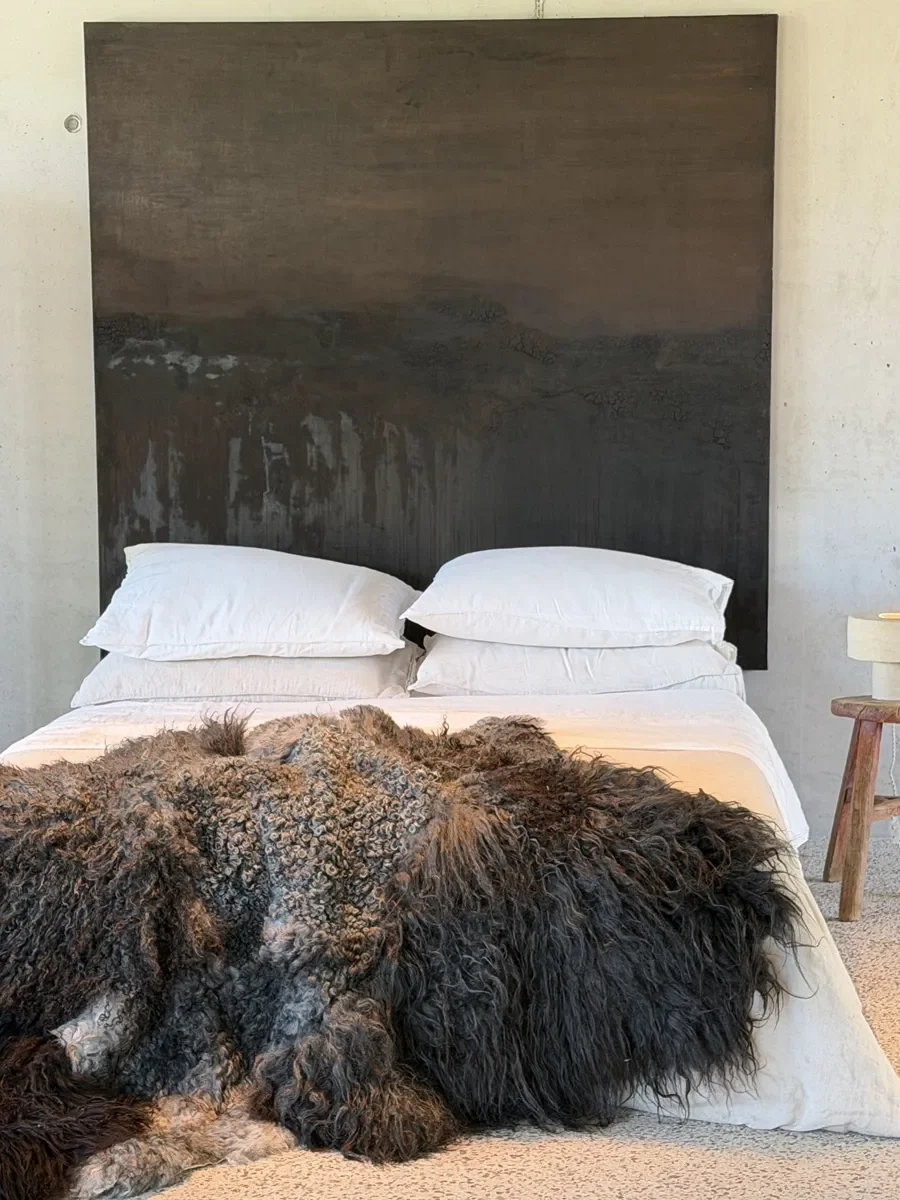 Shadow by Wol Society, a dark sheep skin rug with long black fleece around tight silver grey curls