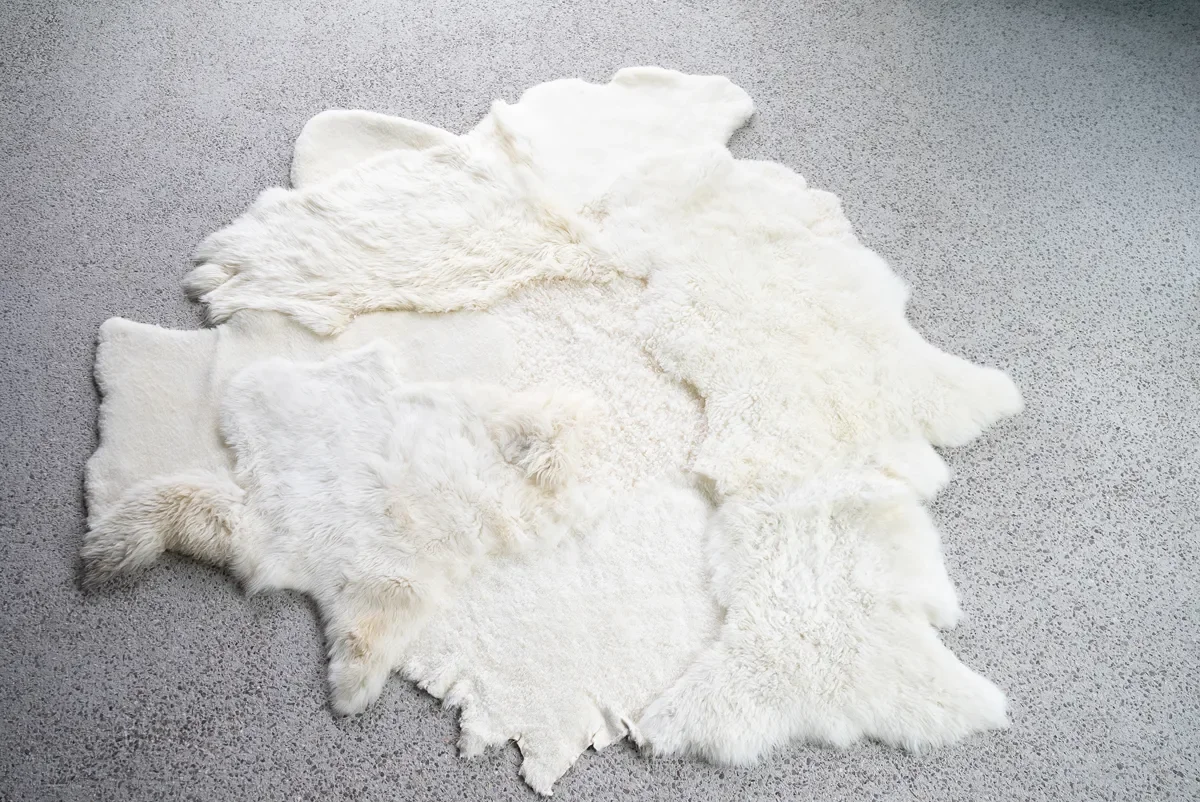 Sjoe by Wol Society, a near-square white sheepskin rug with smooth, curly and fluffy patches