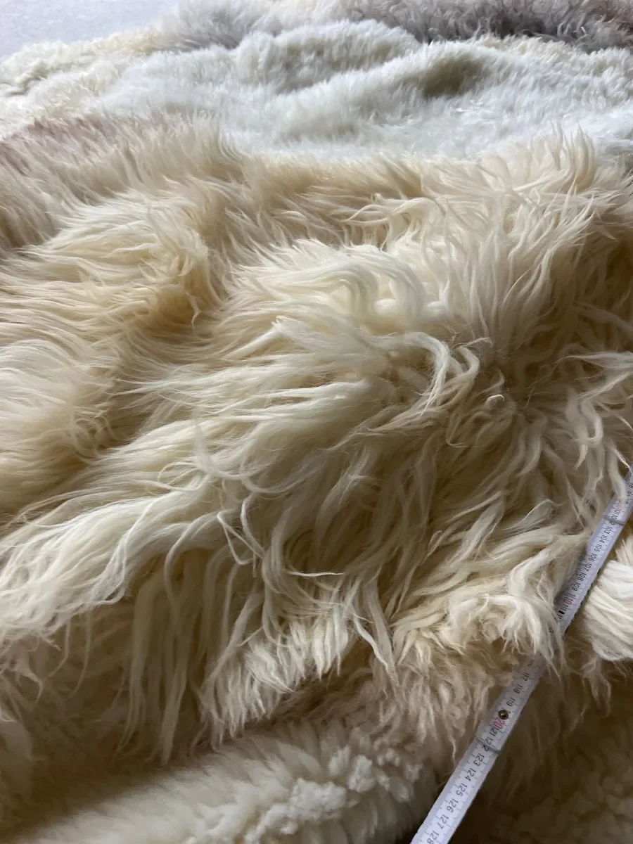 Nomad by Wol Society, a creamy white sheepskin rug with a honey and taupe pelt across the center
