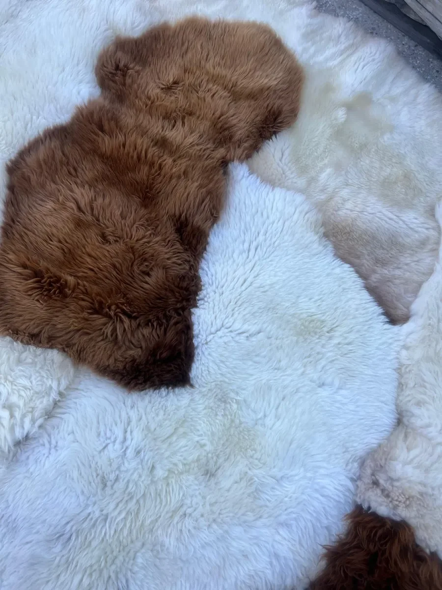 Wolkje by Wol Society, a white sheepskin rug with two chestnut and caramel brown pelts