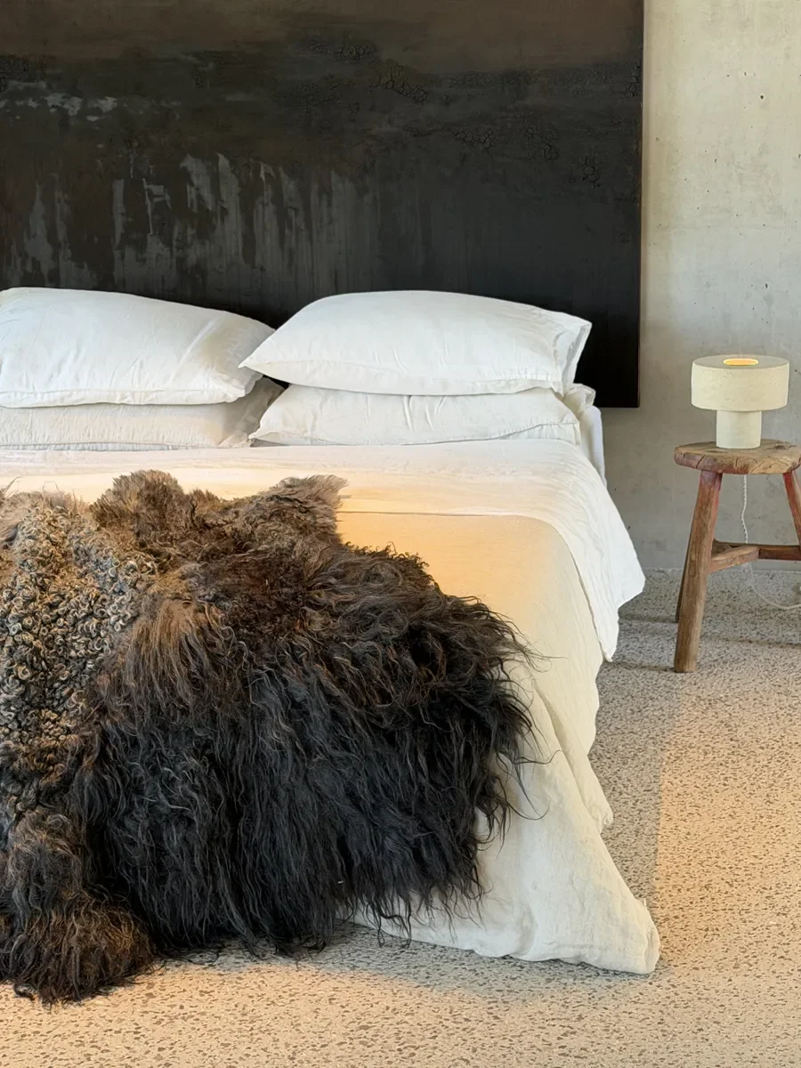 Shadow by Wol Society, a dark sheep skin rug with long black fleece around tight silver grey curls