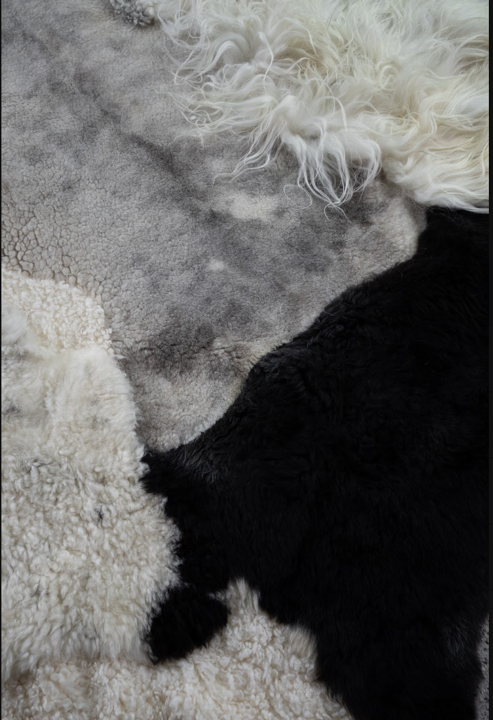 Bohdi by Wol Society, a black and white patchwork sheepskin rug with a smooth dove-grey center
