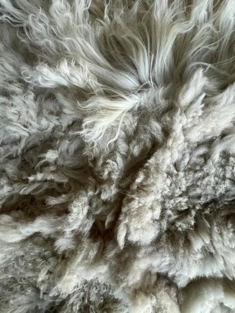 Pixie 2 by Wol Society, an ivory sheep skin rug with long, wavy fleece and soft grey undertones