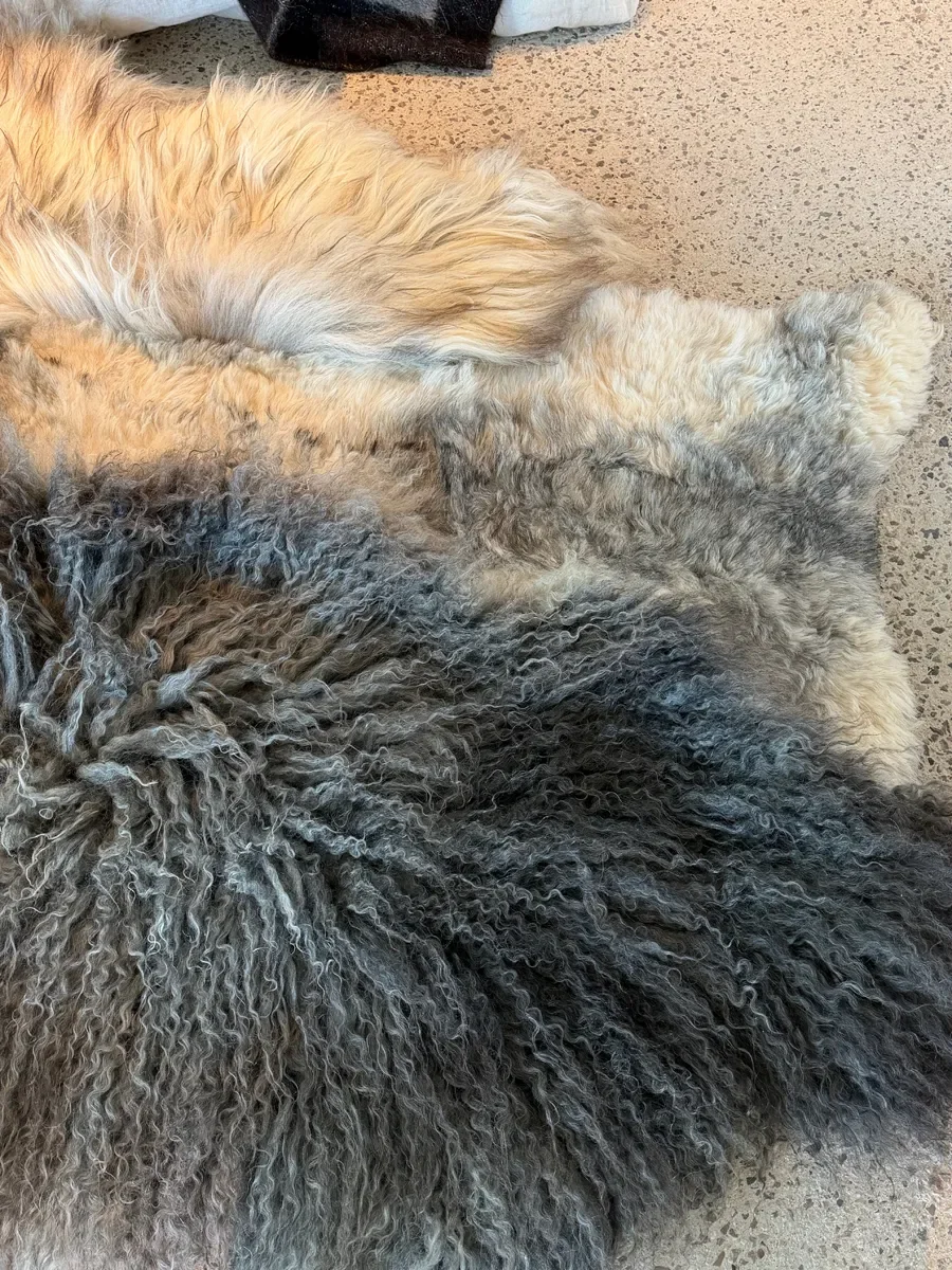 Frost by Wol Society, a grey sheepskin rug with long charcoal curls, silver pelts and honey tips