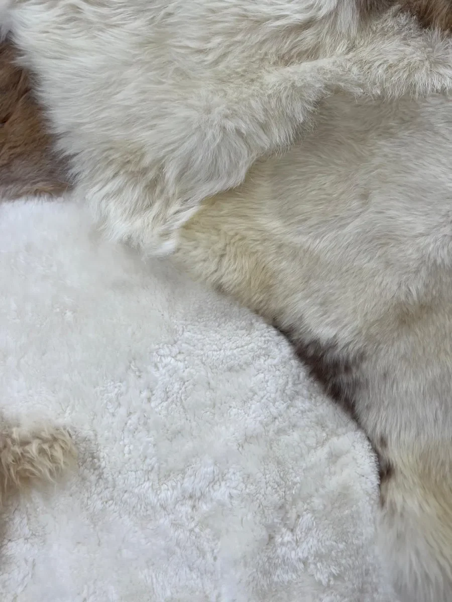 Twinkle by Wol Society, a white sheepskin rug with smooth panels and fluffy cream and taupe pelts