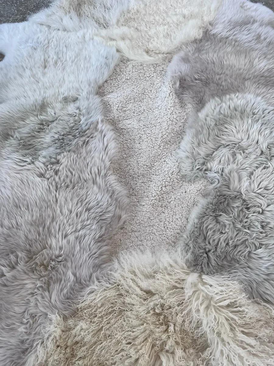 Angelica by Wol Society, a creamy white and pale grey sheep skin rug with rust-tipped edges