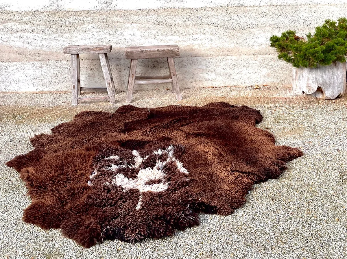 Jackson Hole by Wol Society, a shaggy chocolate brown sheepskin rug with a splash of white at its center