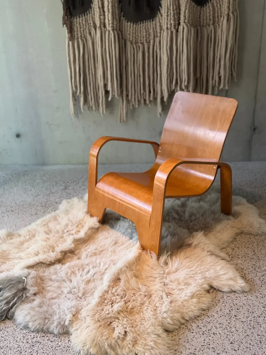 Crumble by Wol Society, a curly ivory and oatmeal sheep skin rug with a shaggy grey tuft