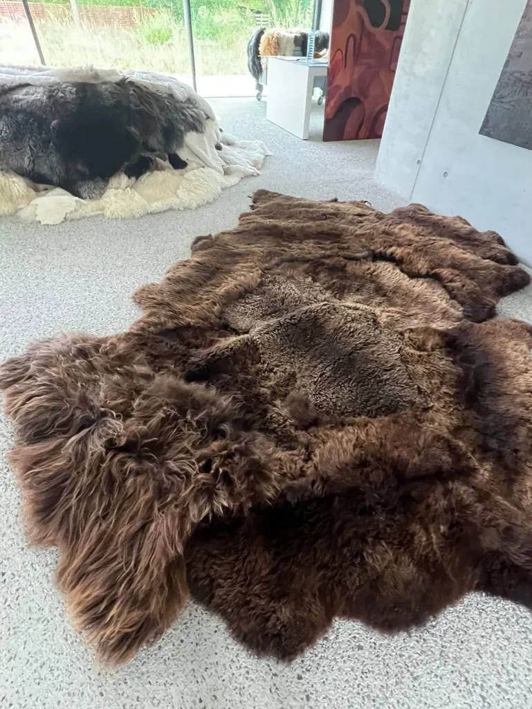 Mieke 204 by Wol Society, a russet brown sheepskin rug with shaggy edges and a curly center