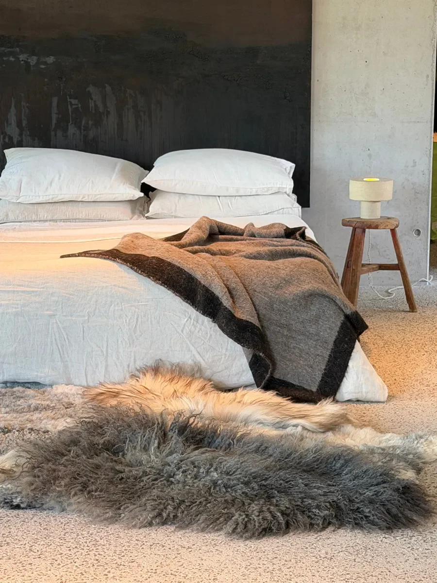 Frost by Wol Society, a grey sheepskin rug with long charcoal curls, silver pelts and honey tips