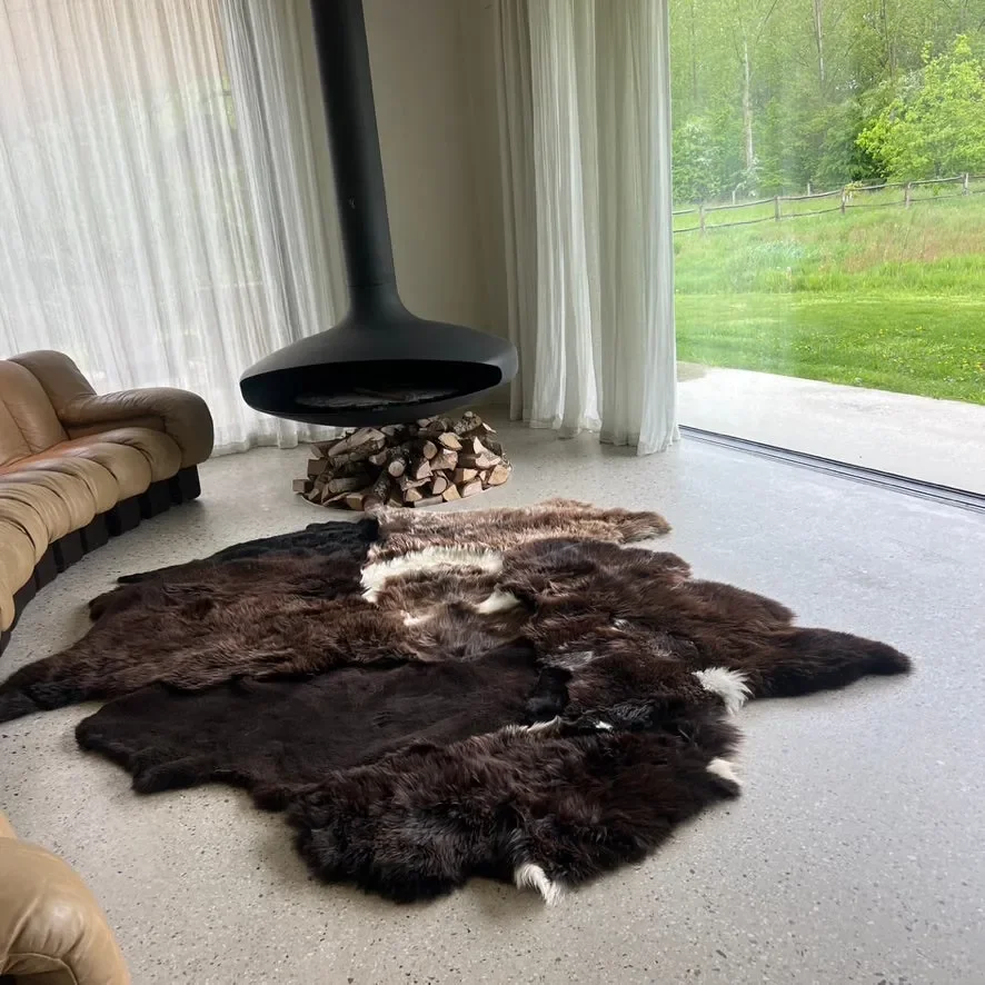 Titan by Wol Society, a dark brown sheepskin rug with a swirl of white at its center