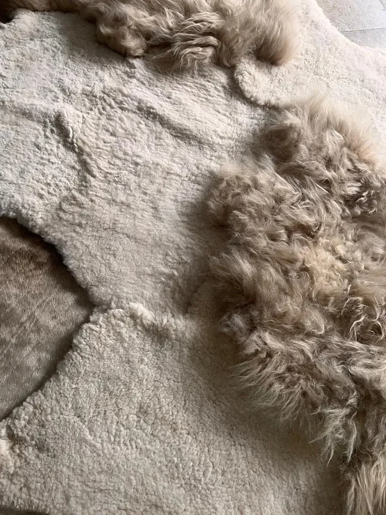 Mieke 196 by Wol Society, an ivory sheep skin rug dotted with long, fluffy taupe pelts