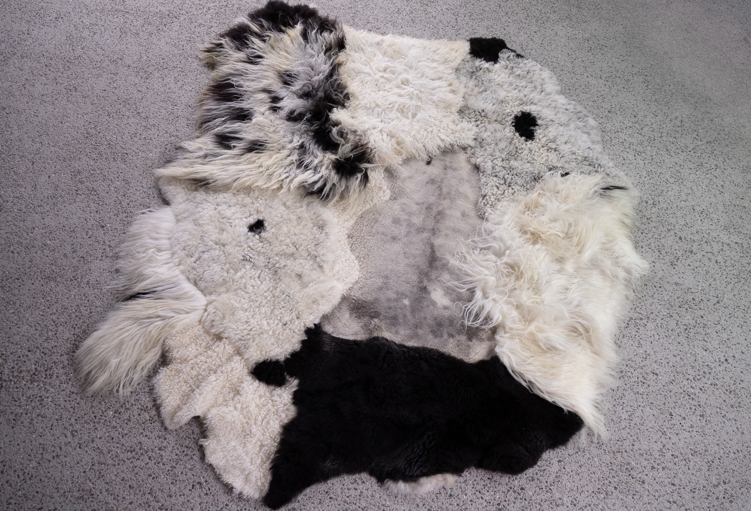 Bohdi by Wol Society, a black and white patchwork sheepskin rug with a smooth dove-grey center