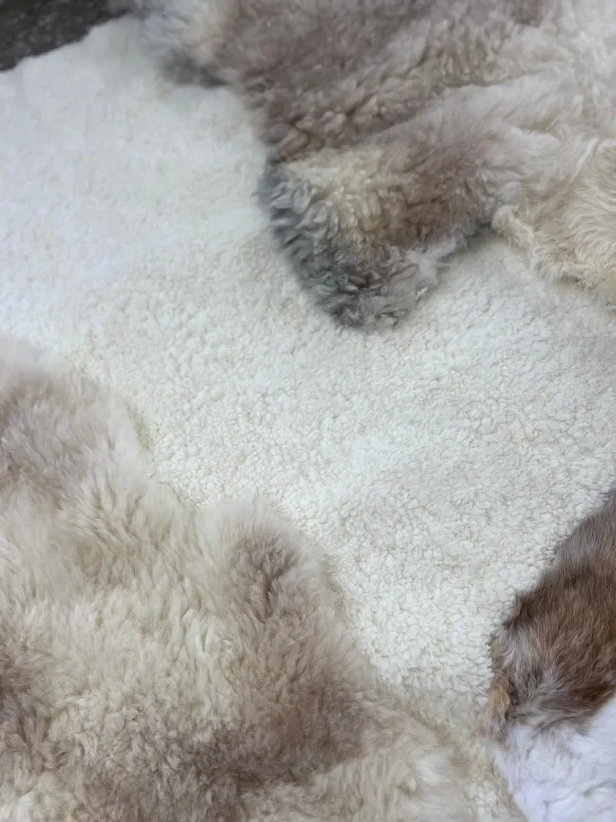 Twinkle by Wol Society, a white sheepskin rug with smooth panels and fluffy cream and taupe pelts