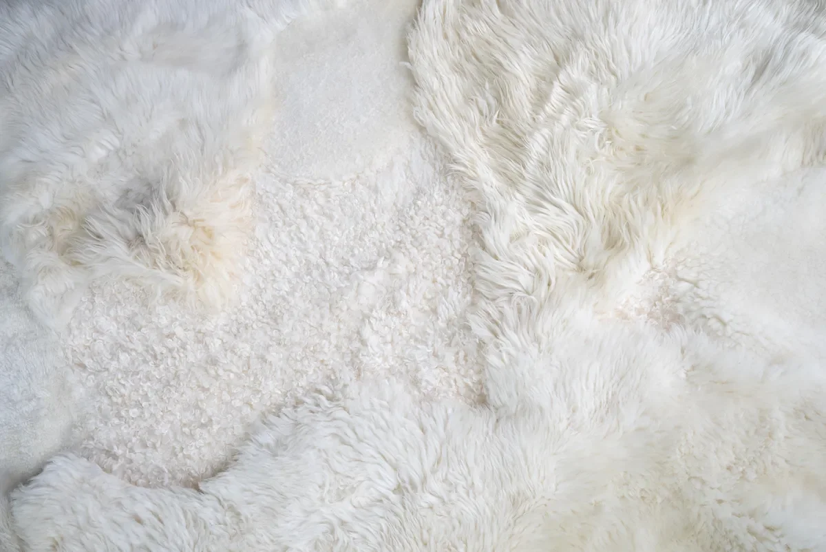 Sjoe by Wol Society, a near-square white sheepskin rug with smooth, curly and fluffy patches