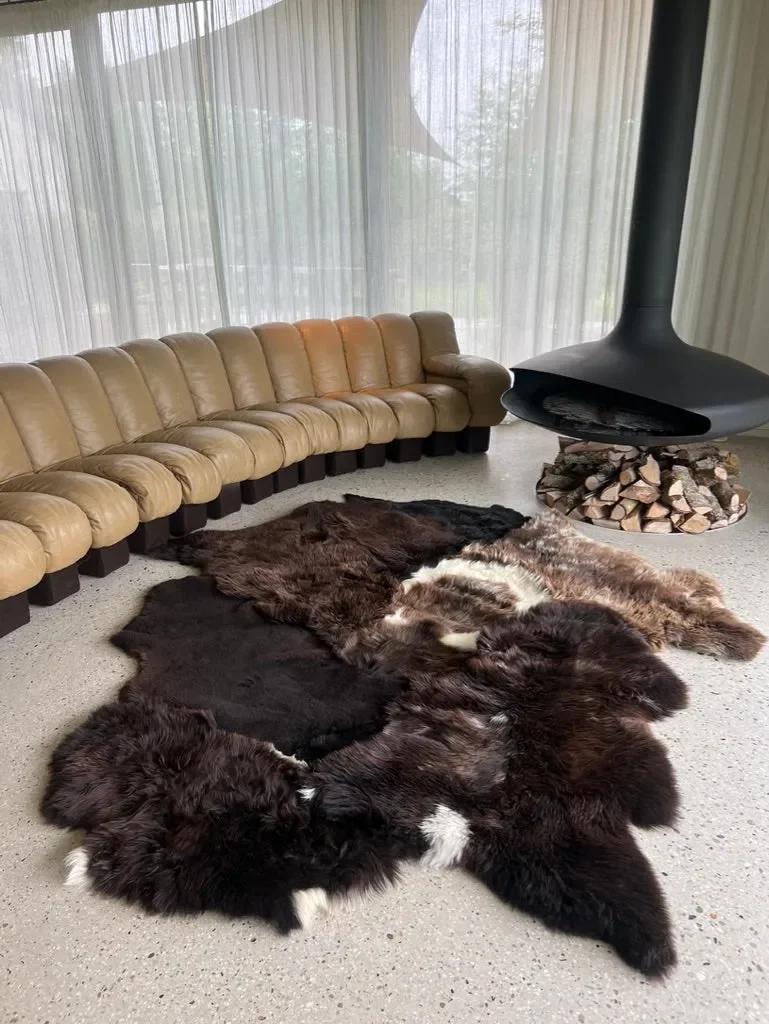 Titan by Wol Society, a dark brown sheepskin rug with a swirl of white at its center