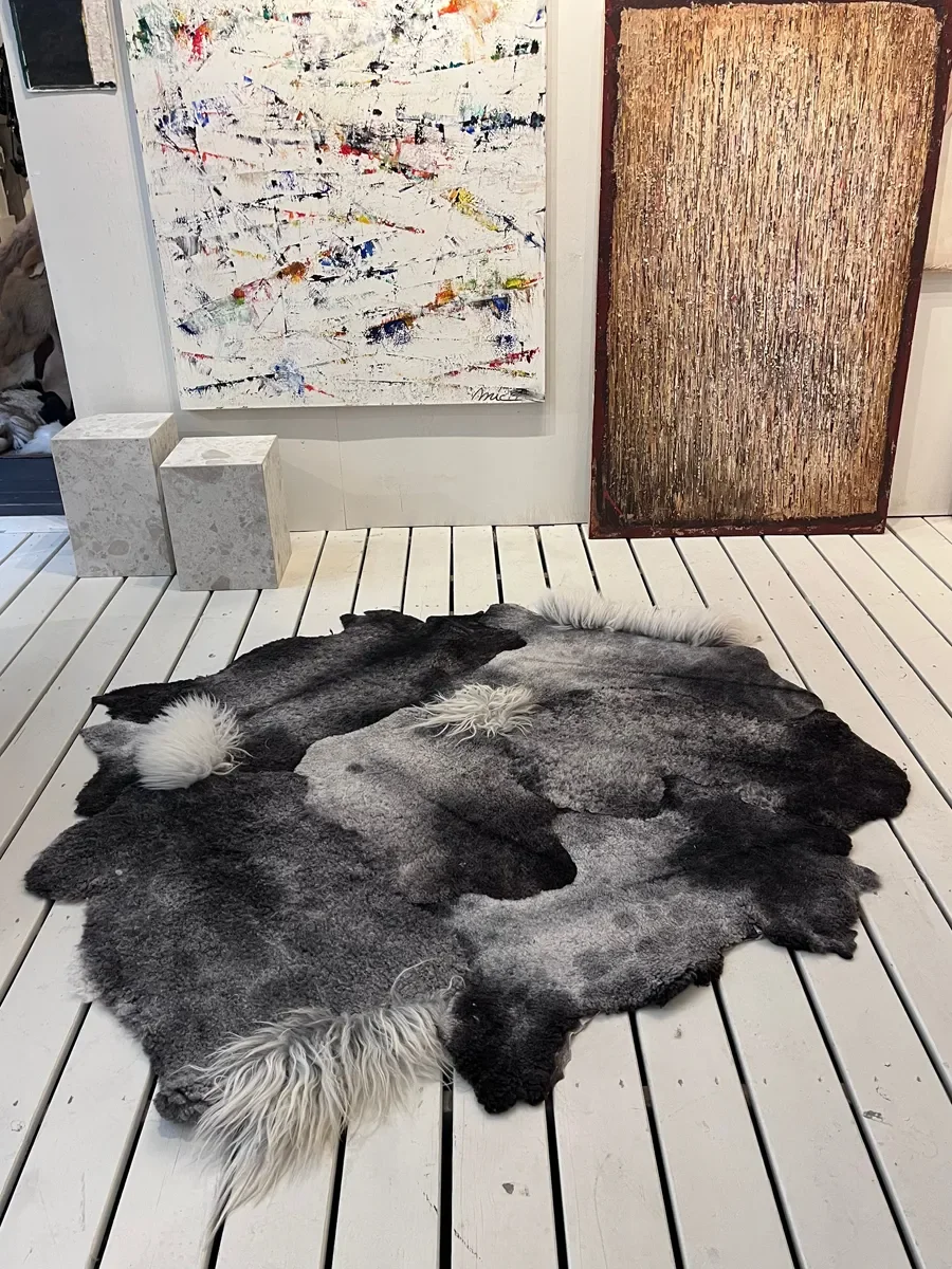 Piece Unique by Wol Society, a charcoal and silver grey Gotland lambskin carpet with tufts of white curls