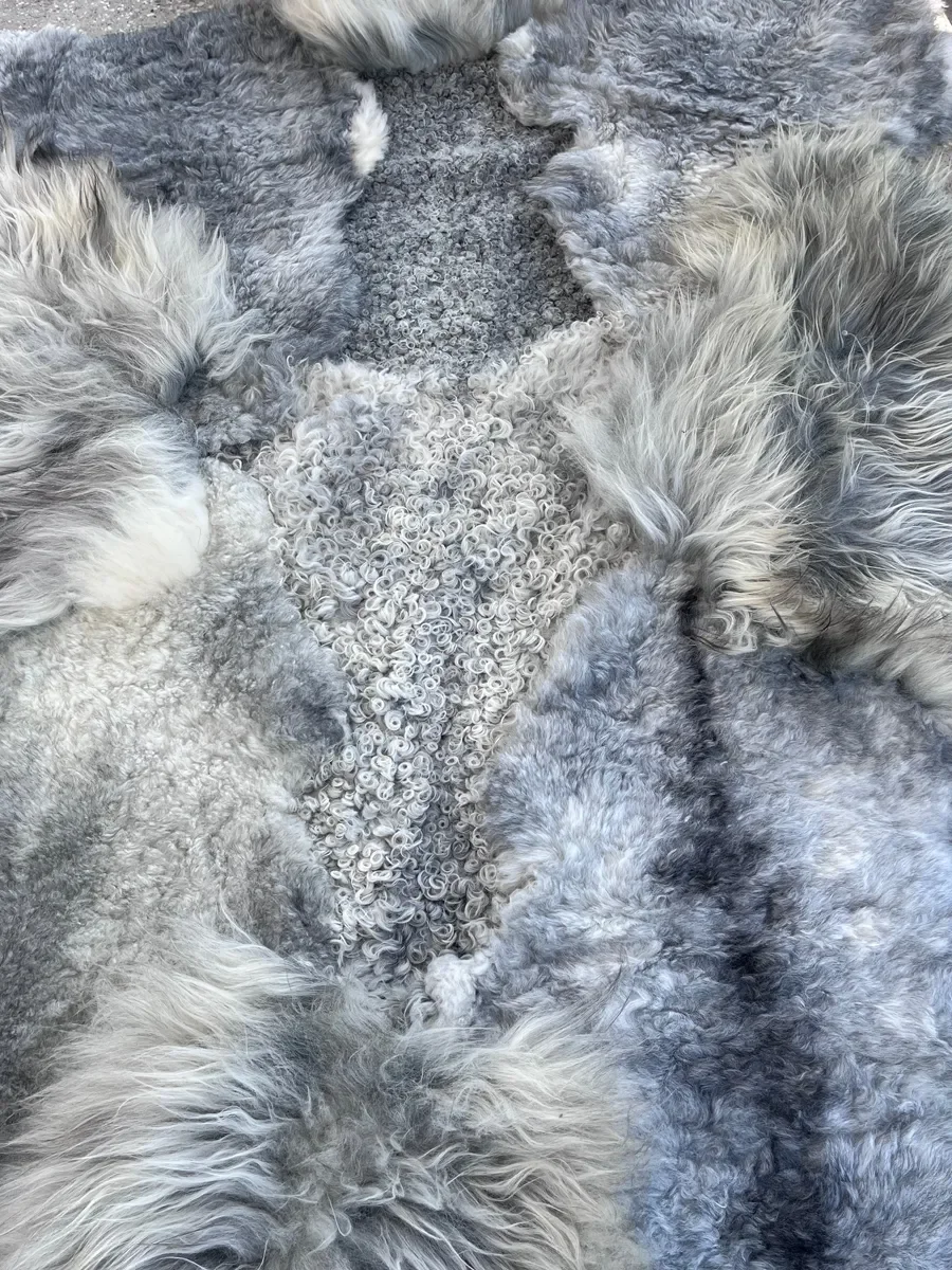 Graphite by Wol Society, a grey sheepskin rug in silver, slate and charcoal with long, silky waves