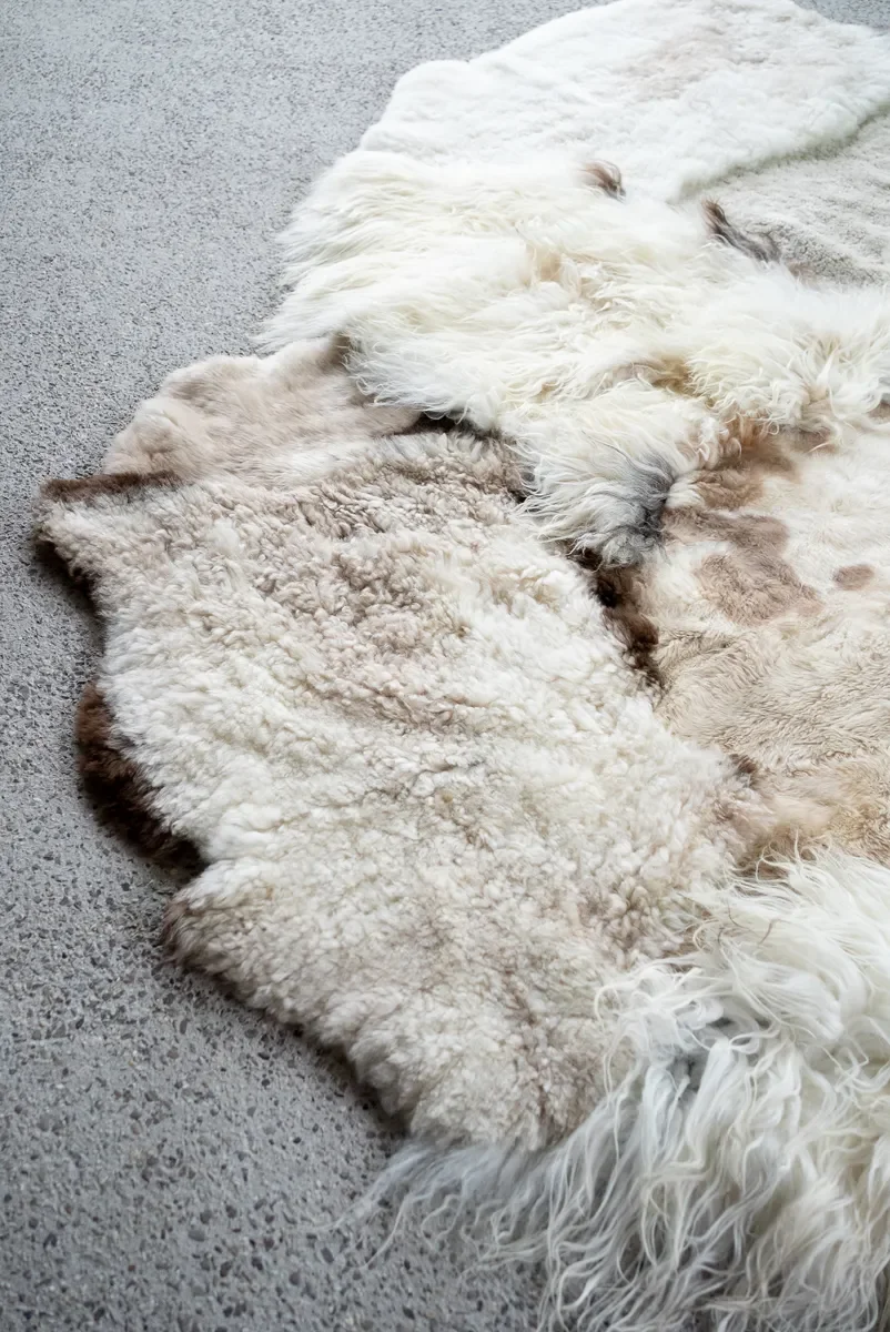 Poppy Puff by Wol Society, an ivory patchwork sheepskin rug with taupe spots and brown-edged pelts