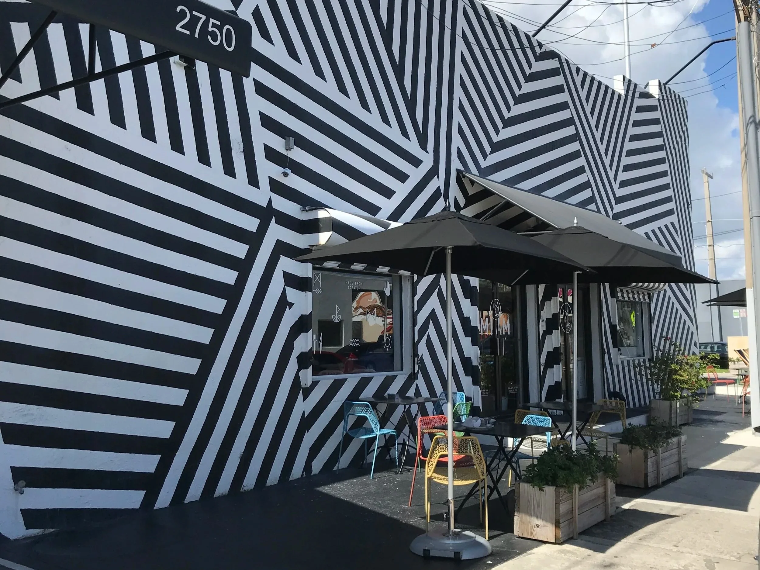 Wynwood Walls, black and white geometric designs on a building with a side window to order and a small outdoor table to eat.