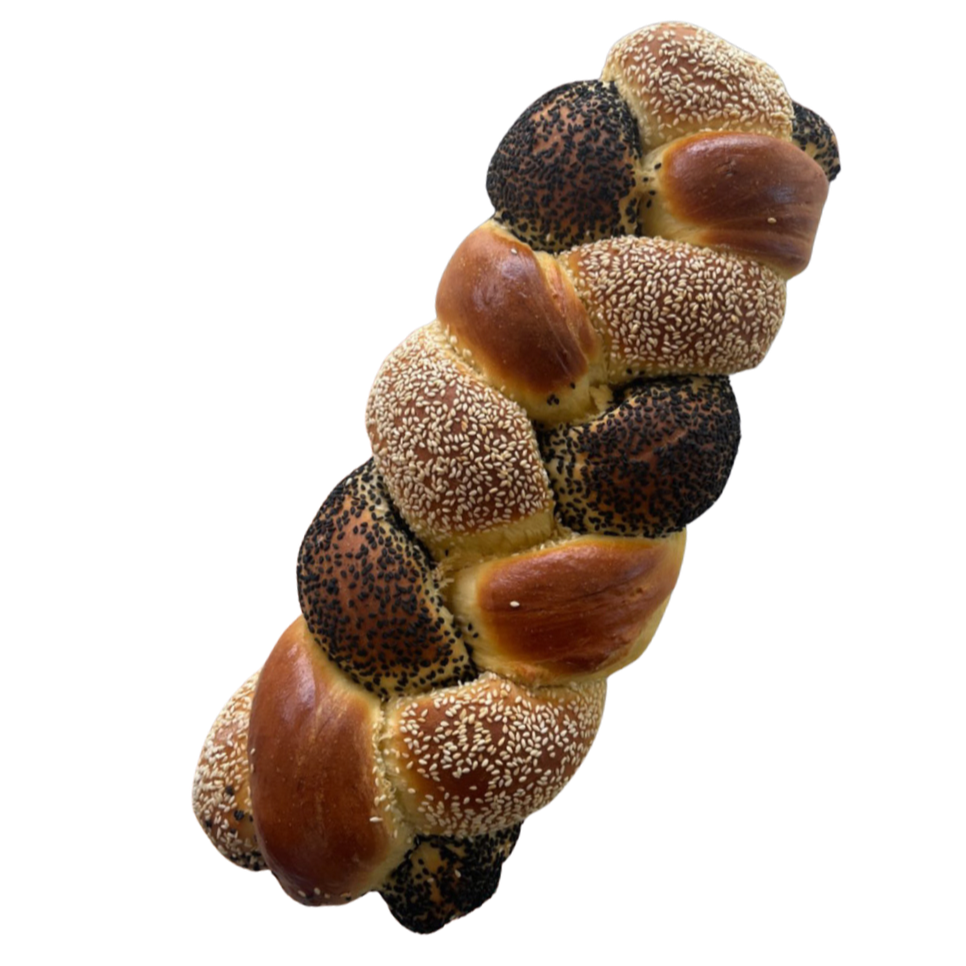 Close-up view of a braided bread loaf topped with poppy seeds and sesame seeds.