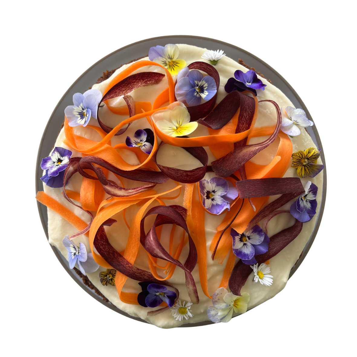 A cheese and vegetable pizza topped with carrot and purple and yellow edible flowers.