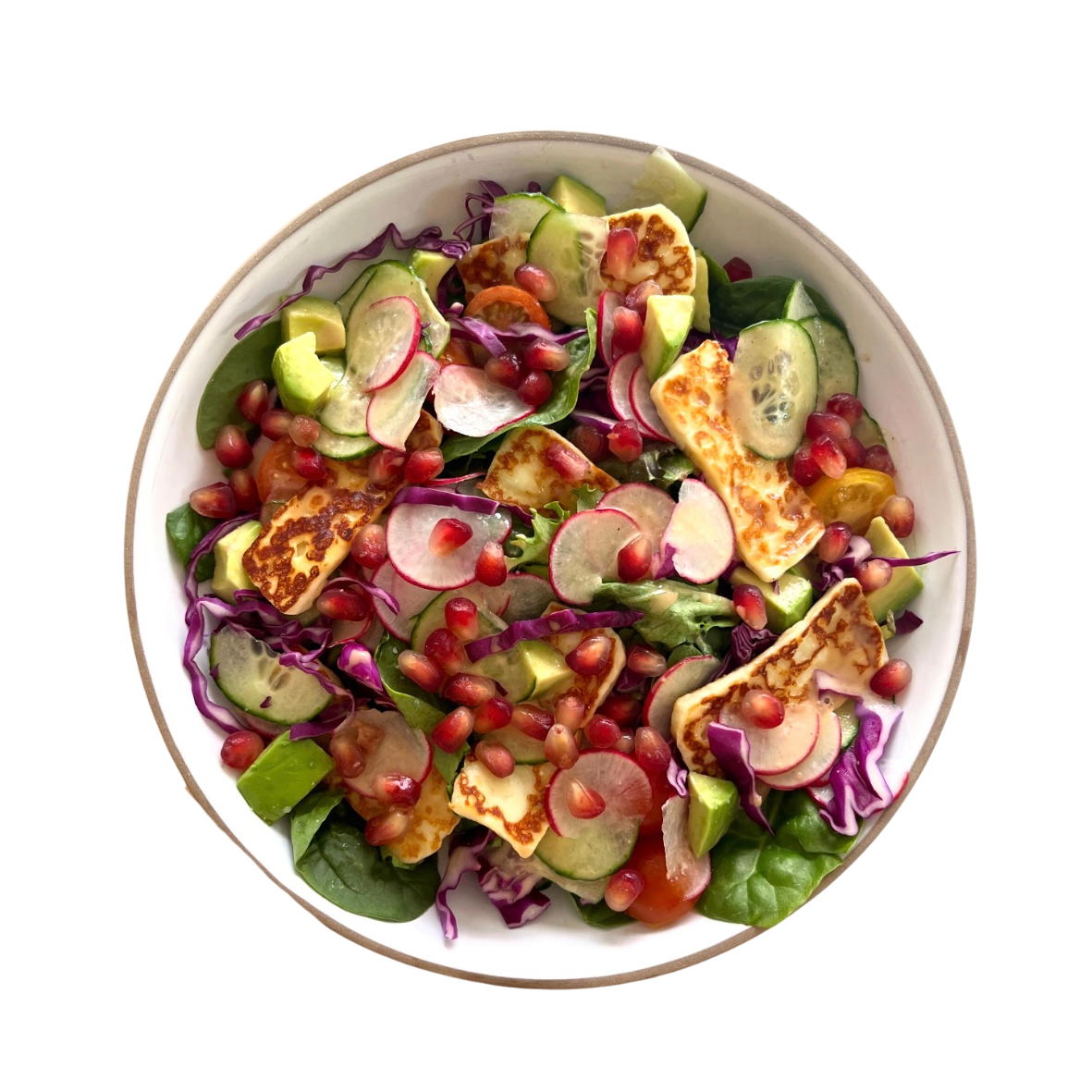 A bowl of salad with cucumbers, radishes, cherry tomatoes, purple cabbage, avocado, pomegranate seeds, and grilled halloumi cheese.