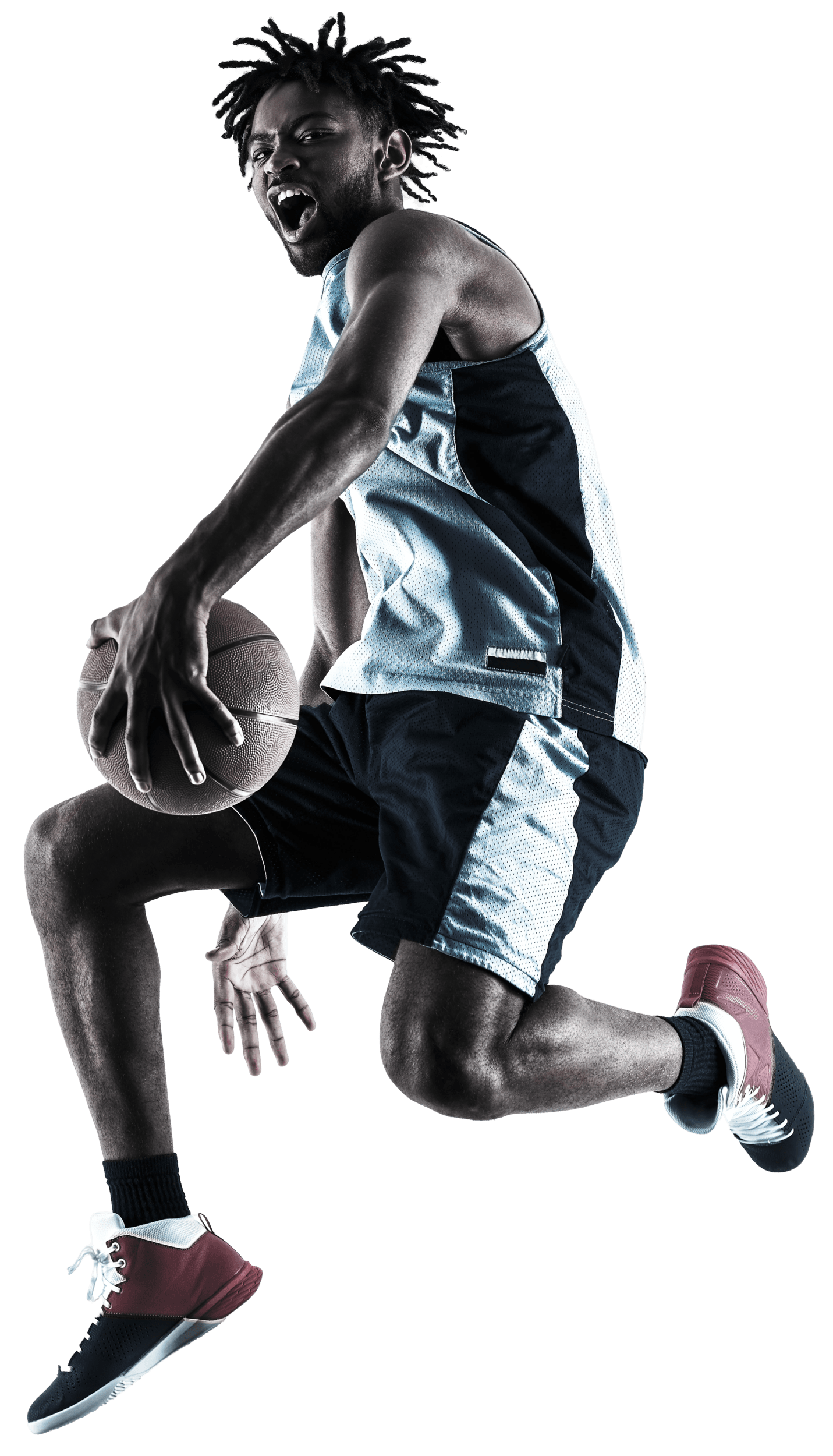 Basketball player in a low stance in mid air after dribbling the ball to the basket.