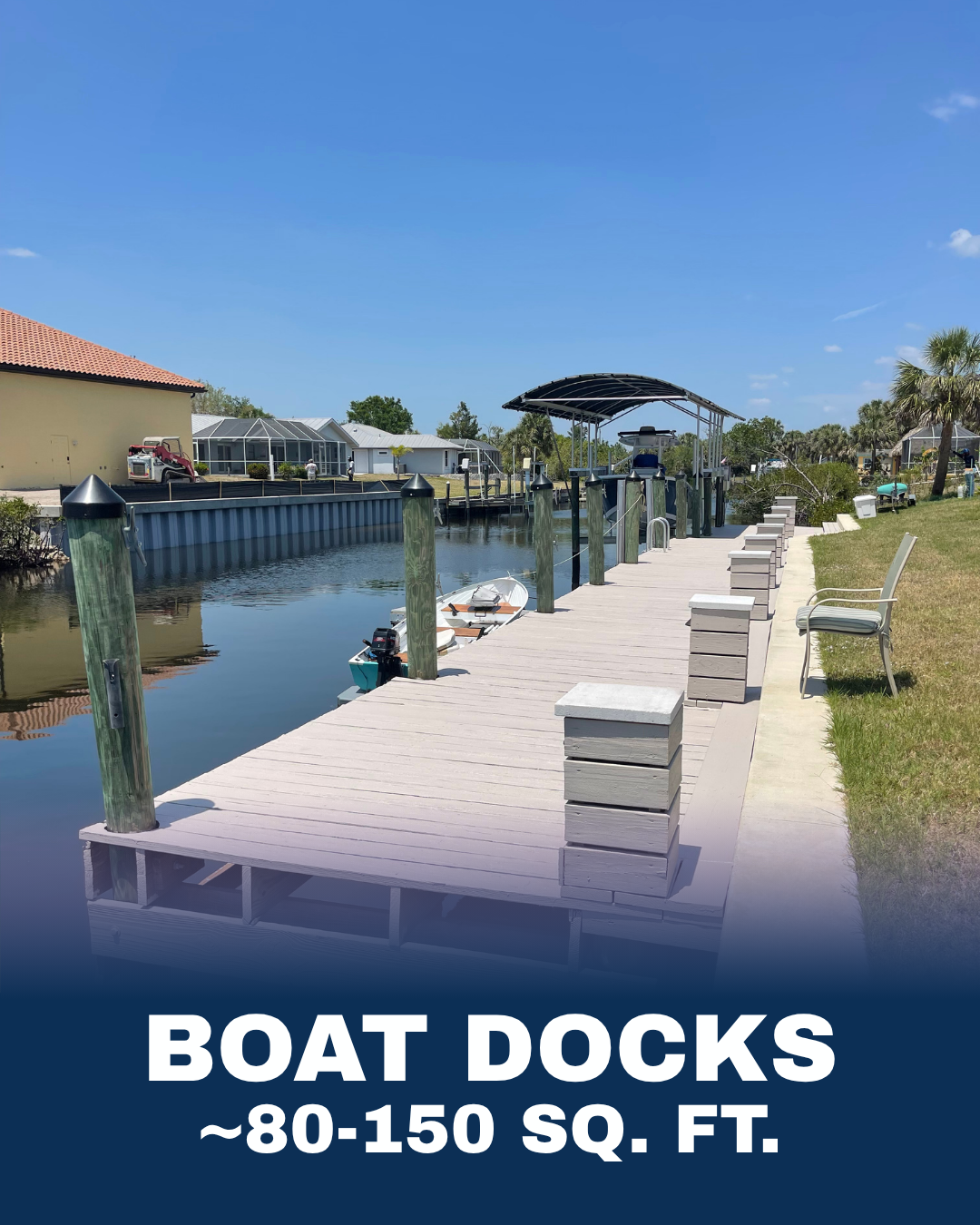 A sunny day at a waterfront with a wooden boat dock, small boat tied to dock, covered boat lift, and nearby chairs on grassy area.
