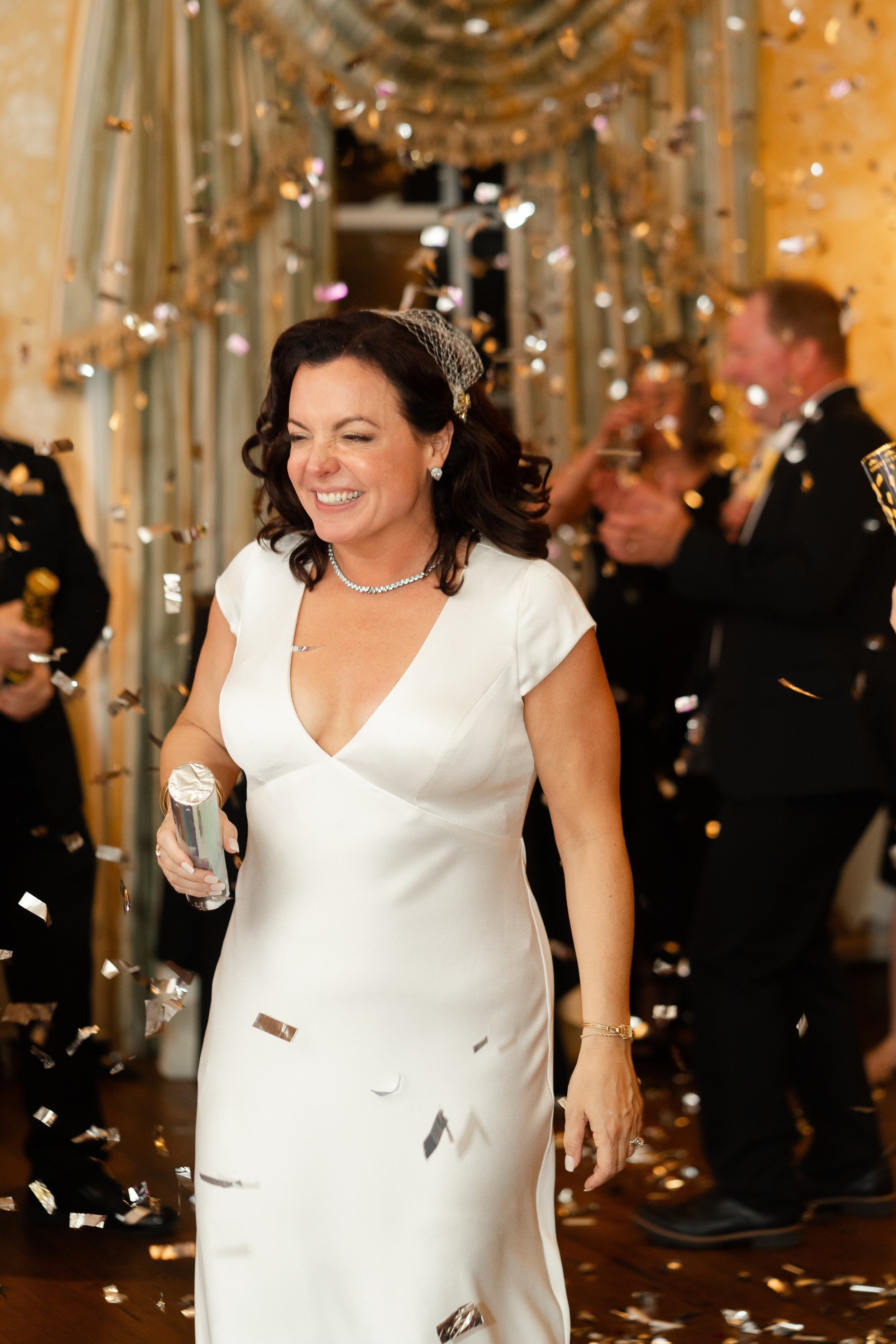 Woman in a white dress smiling and walking toward the camera during a lifestyle photography session