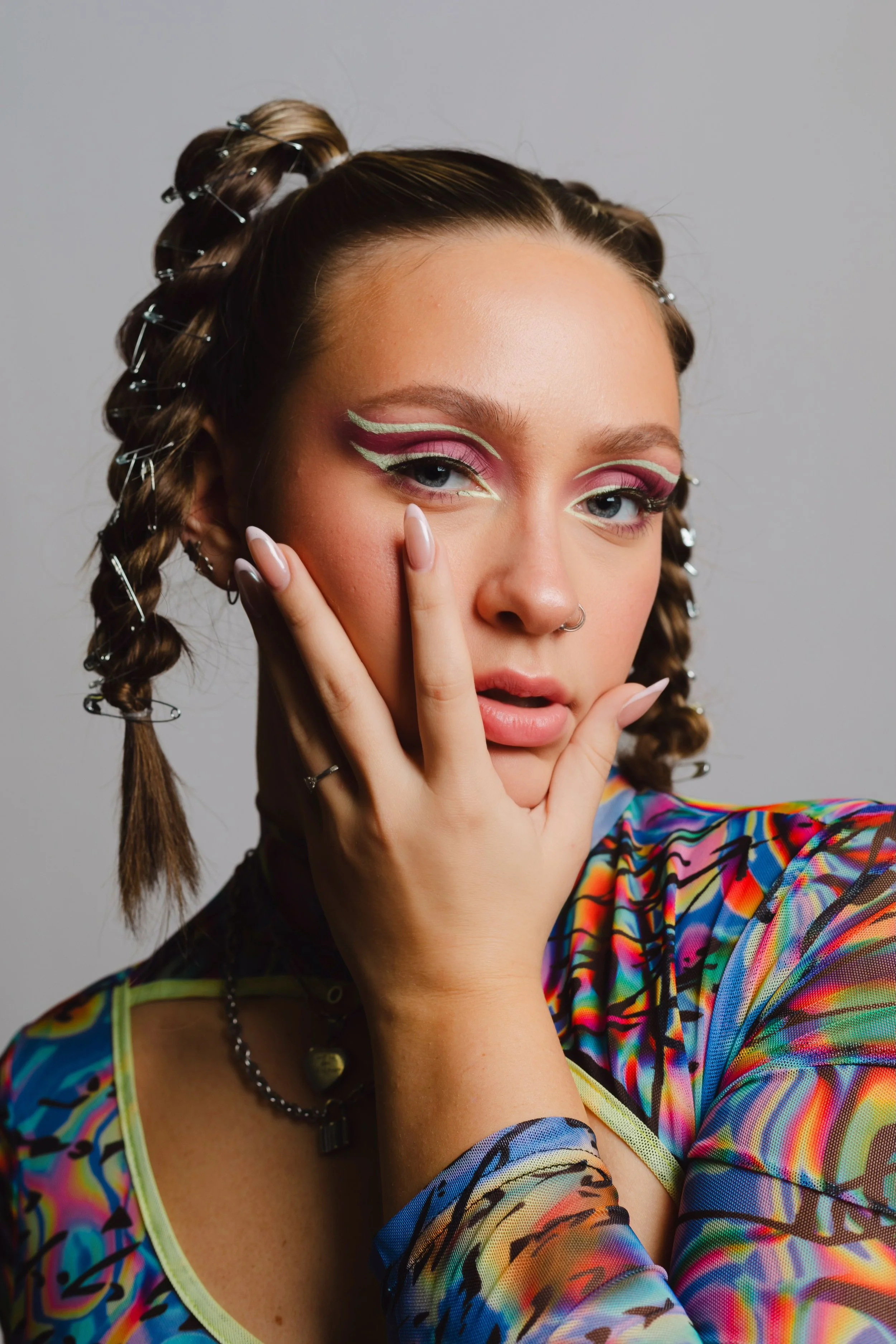Woman with braided hair and colorful graphic eyeliner in a bold beauty portrait