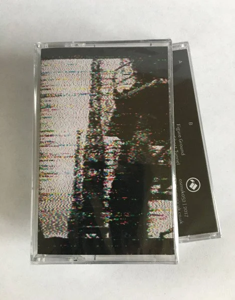 A cassette tape with a distorted, glitchy black and white image on the label.