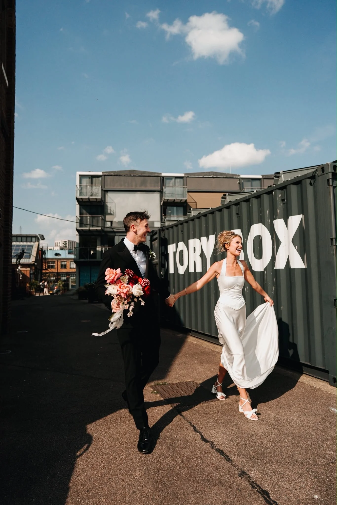 Earth Bridal bride and groom walking through east London, sustainable animal free wedding dress made in London