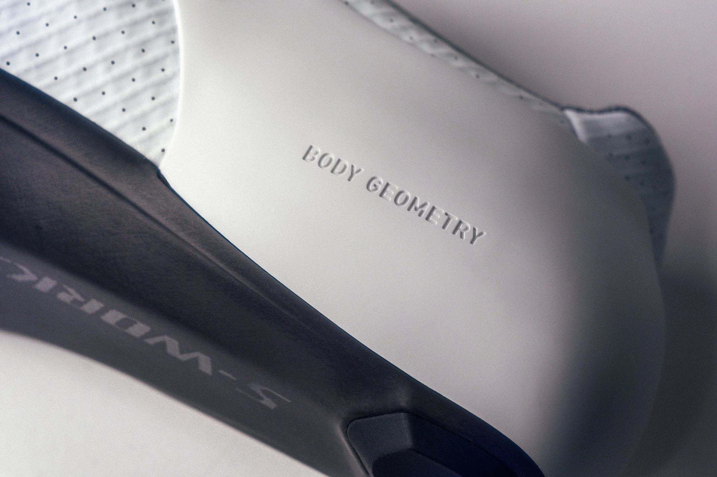 Close-up of a digital body composition monitor displaying the words 'BODY GEOMETRY' engraved on its surface.