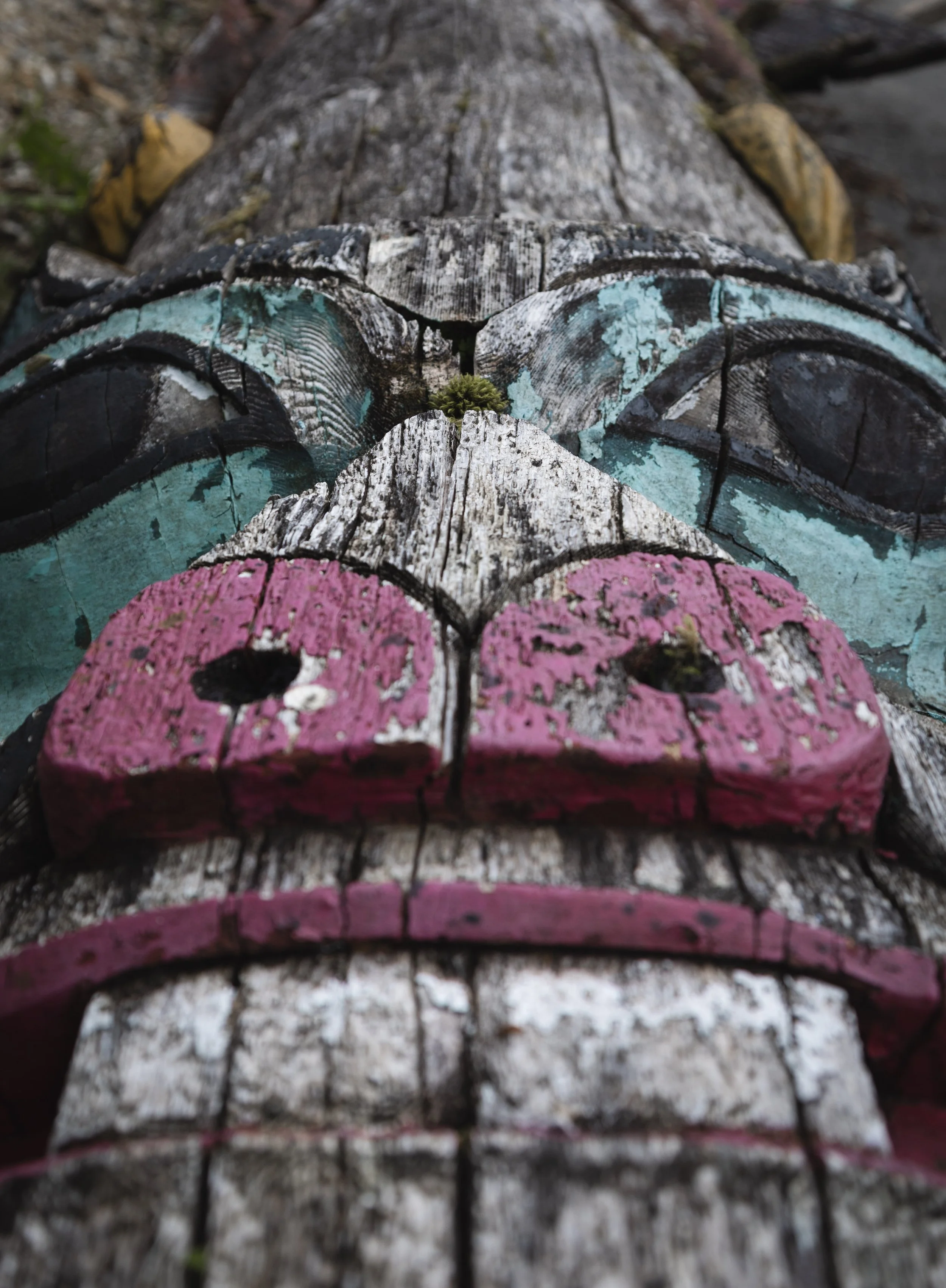 old totem pole in the alaskan forest