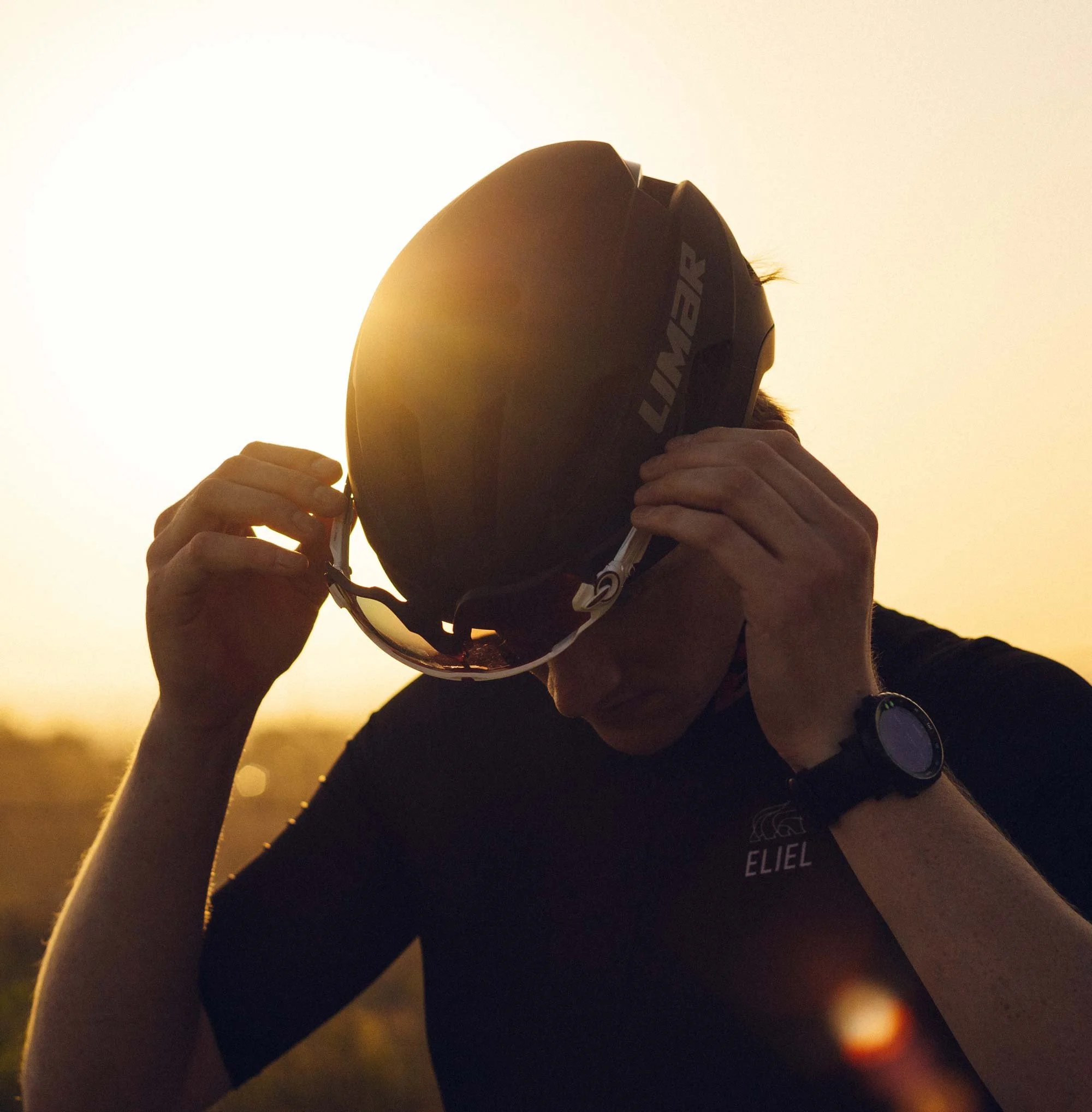 portrait photo of cyclist adjust glasses in sunset