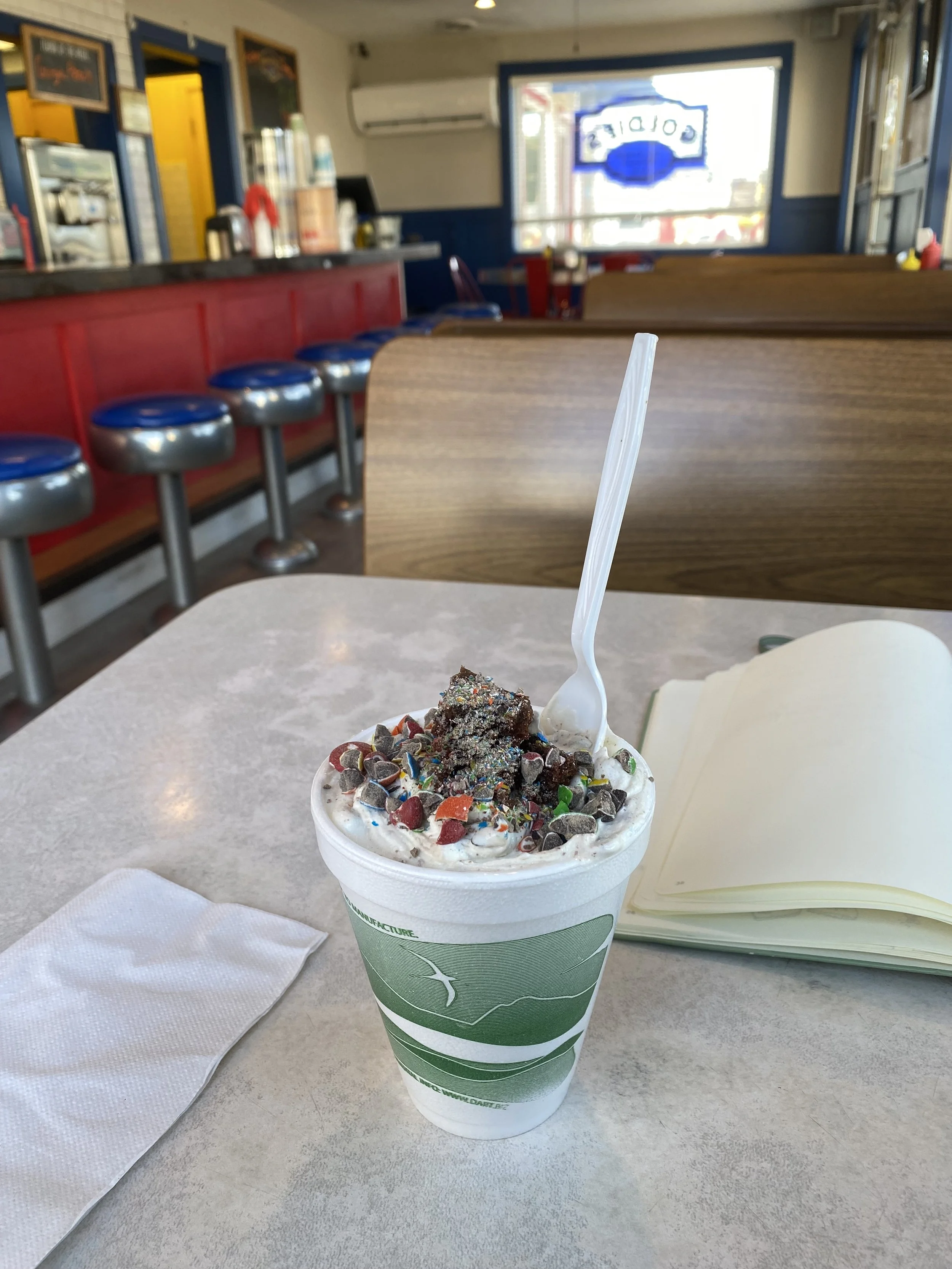 A cup of ice cream sitting on a diner table