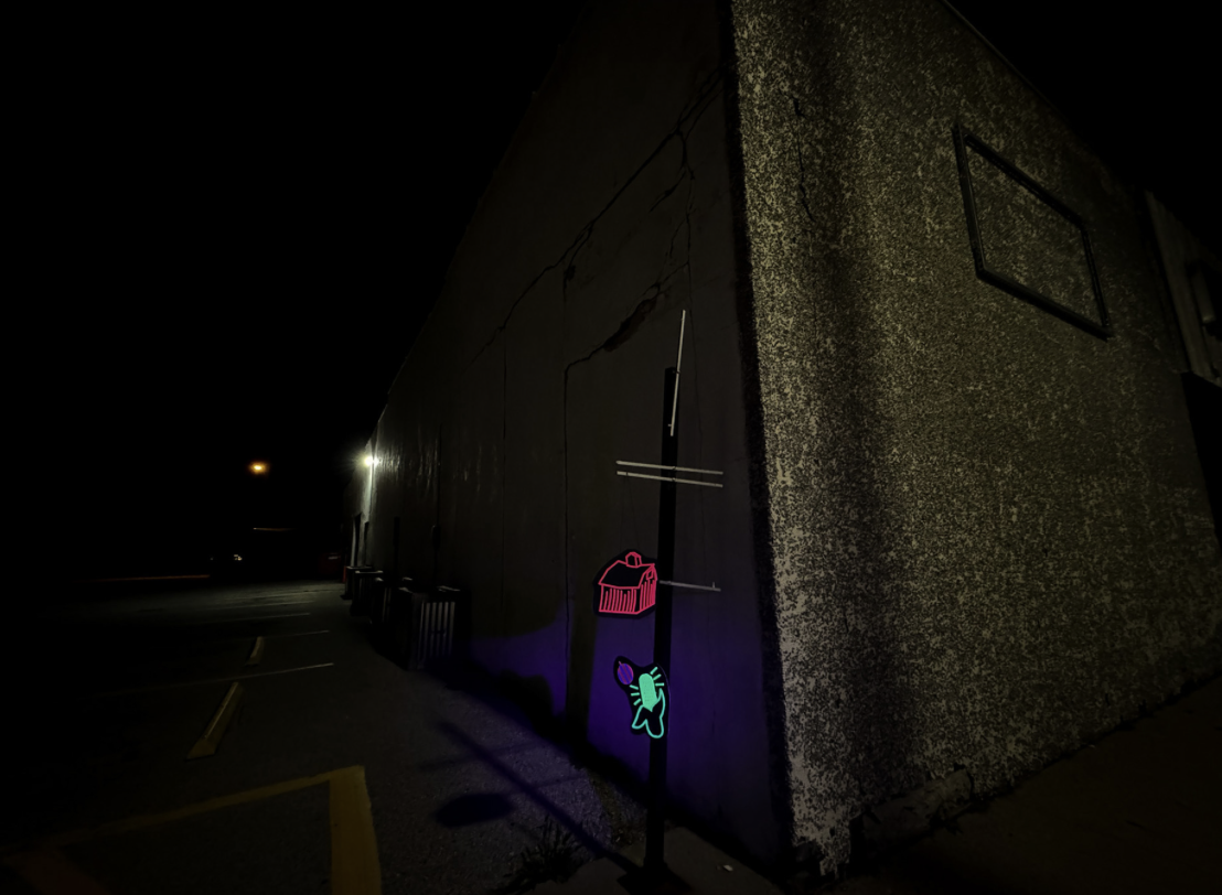 Neon sign in a dark parking lot