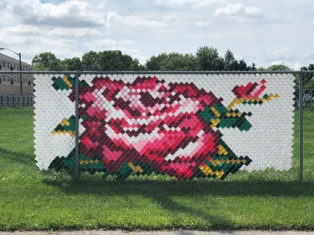 Pink rose design on a fence using cups