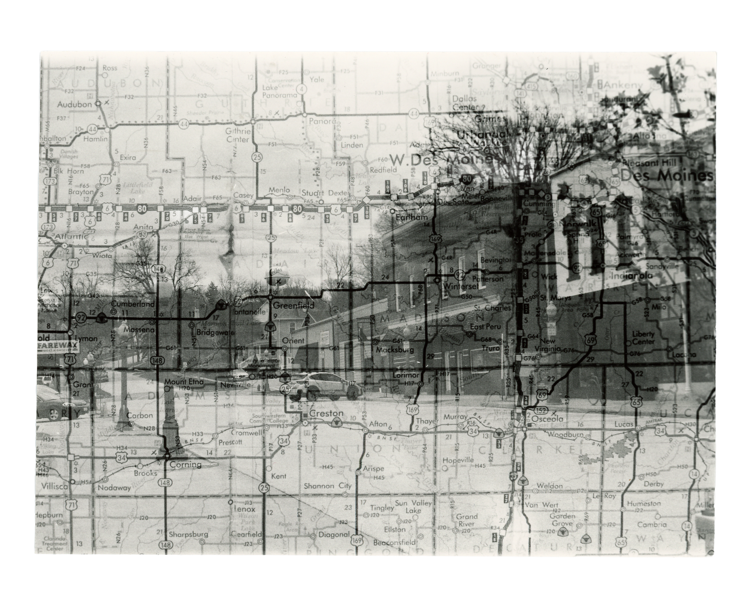 Black and white film photo of a town with a map overlay