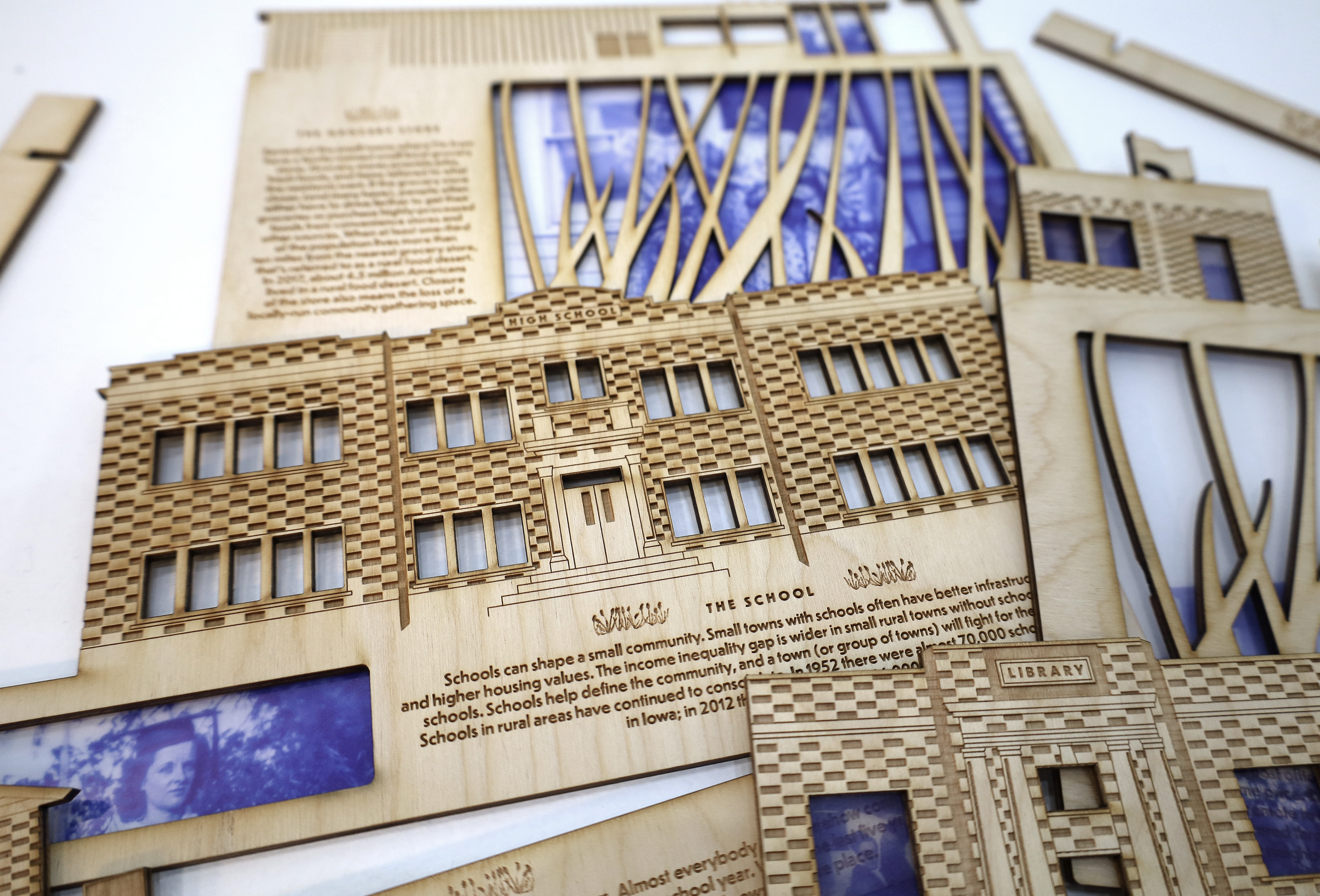 Laser cut wooden buildings lay on a white surface