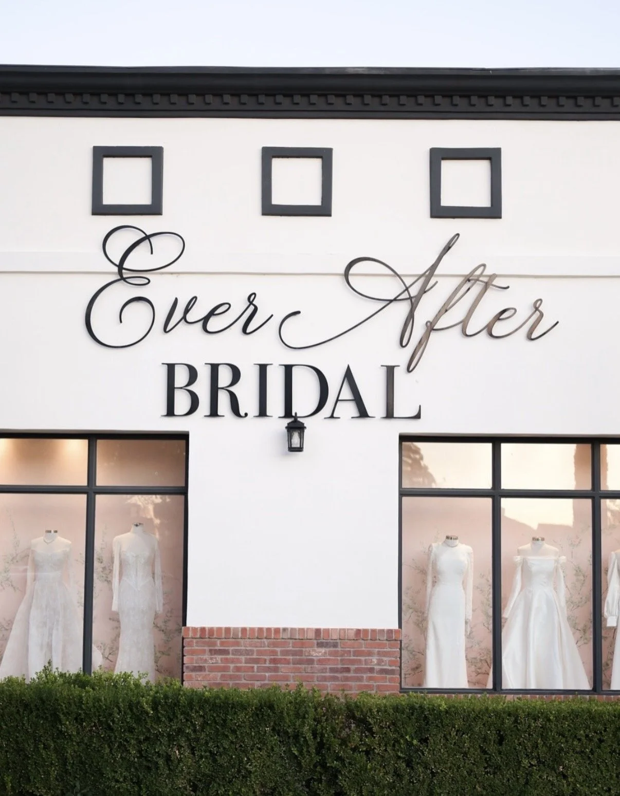 Exterior of Ever After bridal shop with large windows displaying wedding dresses, and a sign reading 'Ever After Bridal' on the white facade.